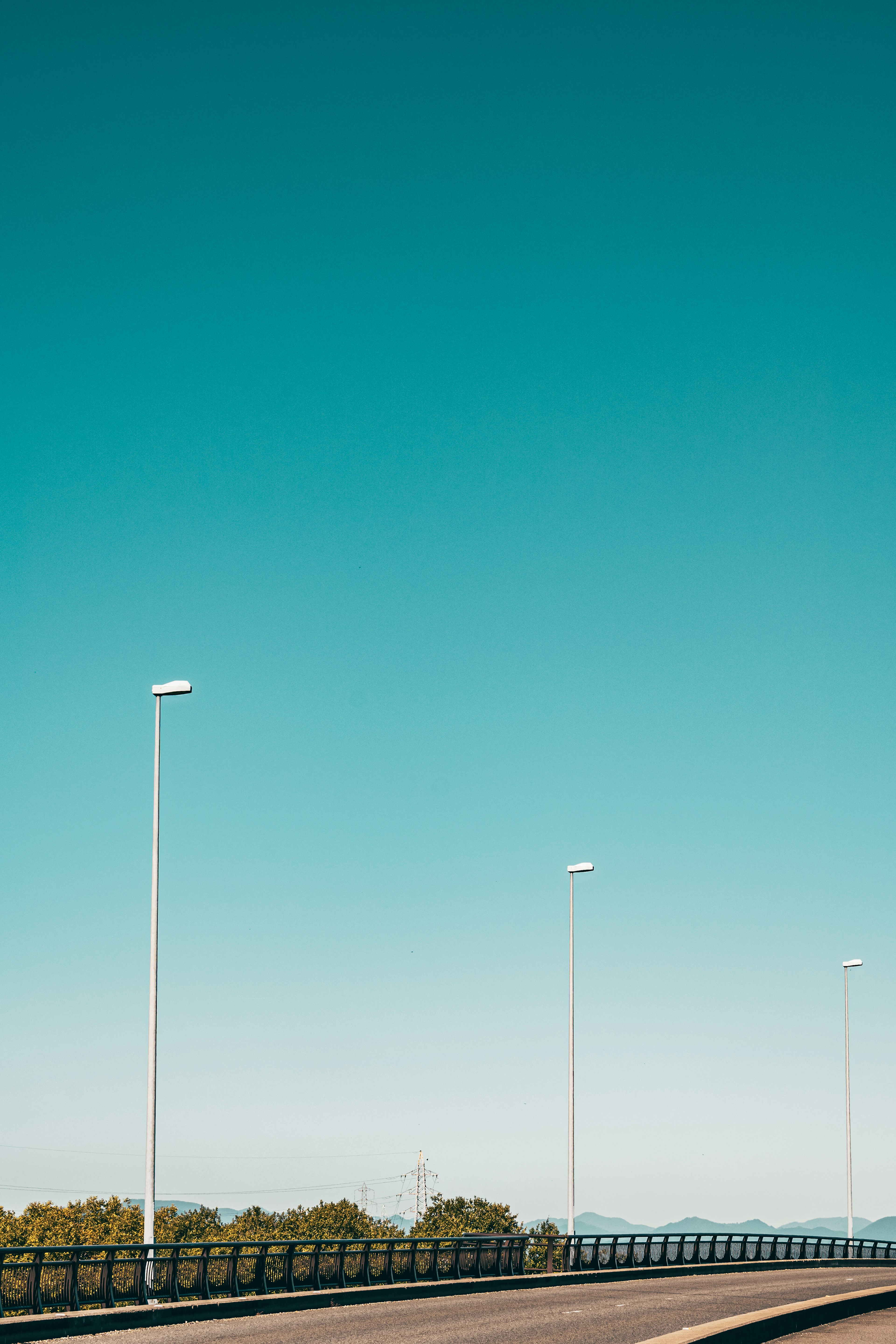 Paysage d'une route avec des lampadaires sous un ciel bleu clair