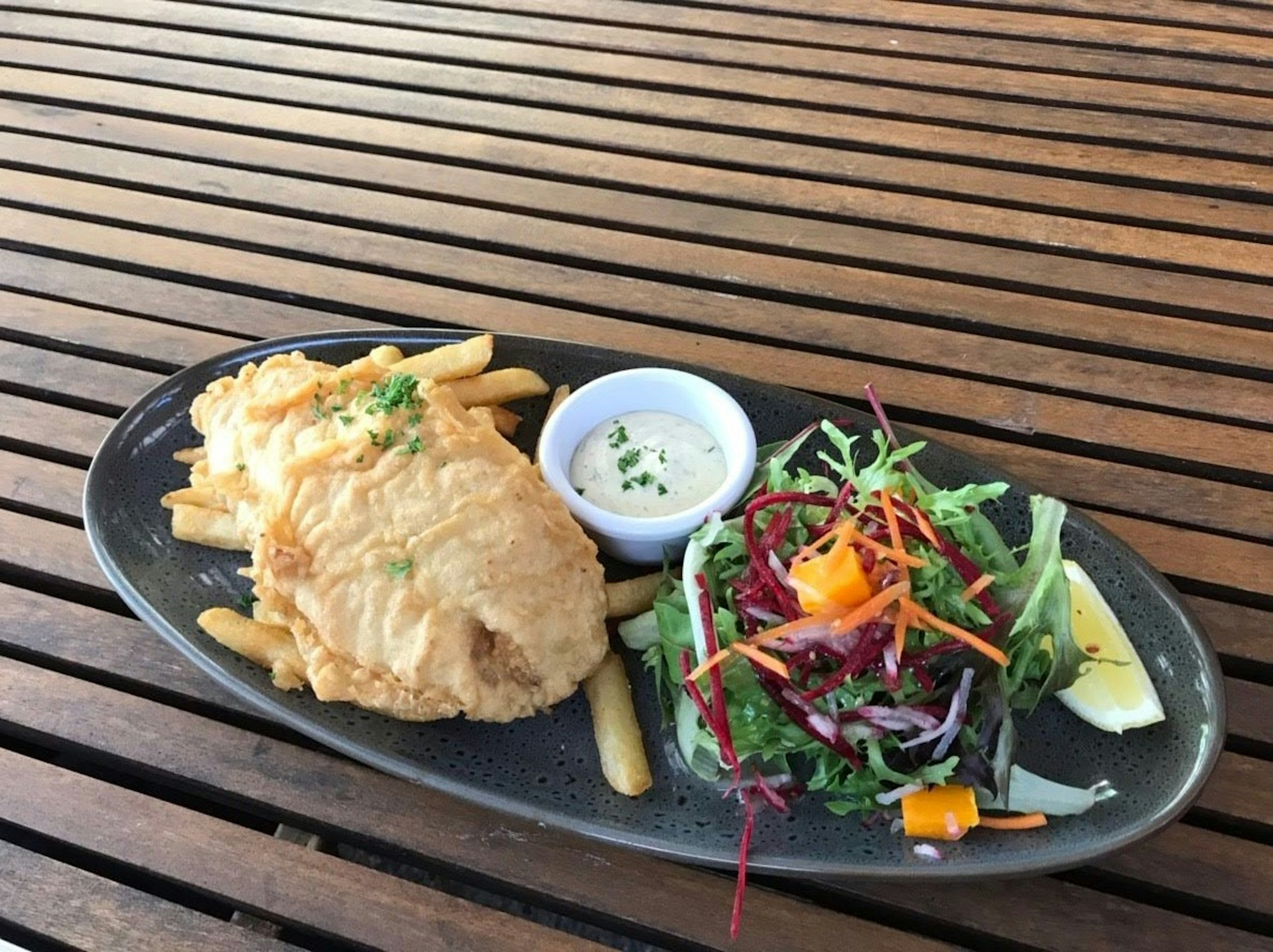 Piatto di pesce fritto con patatine e insalata fresca