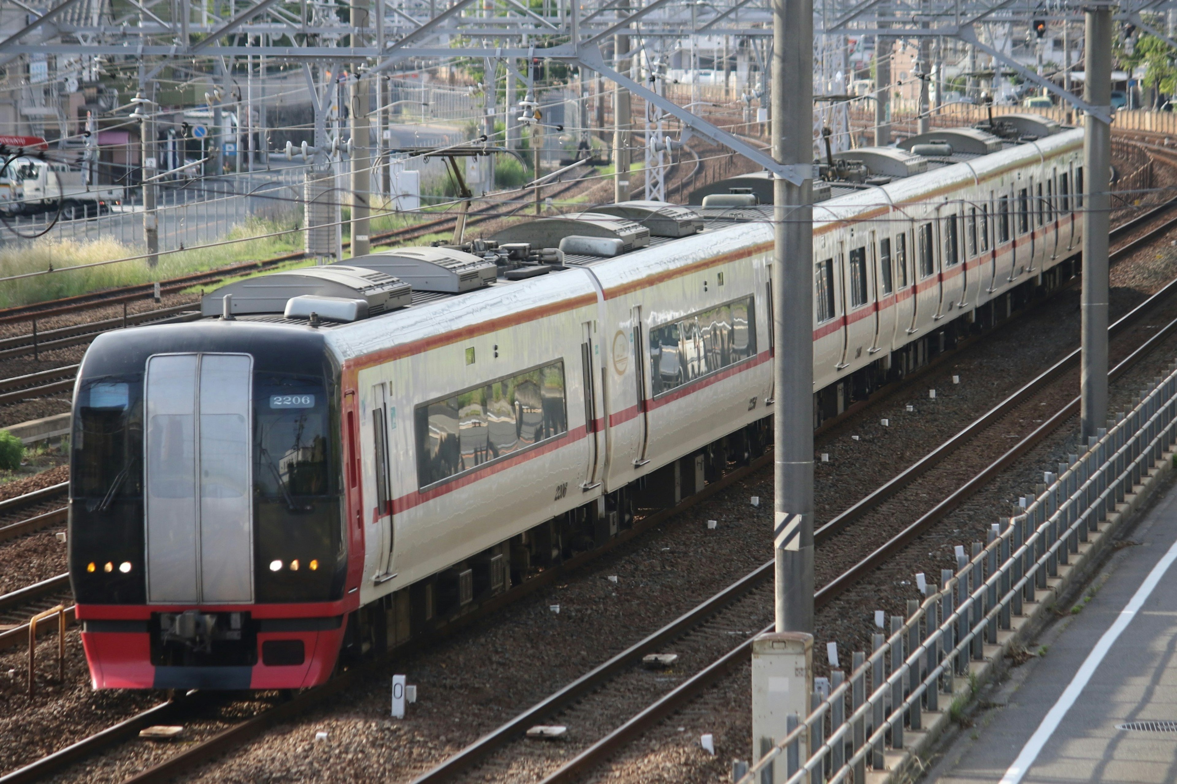 Treno moderno con strisce rosse che corre su binari