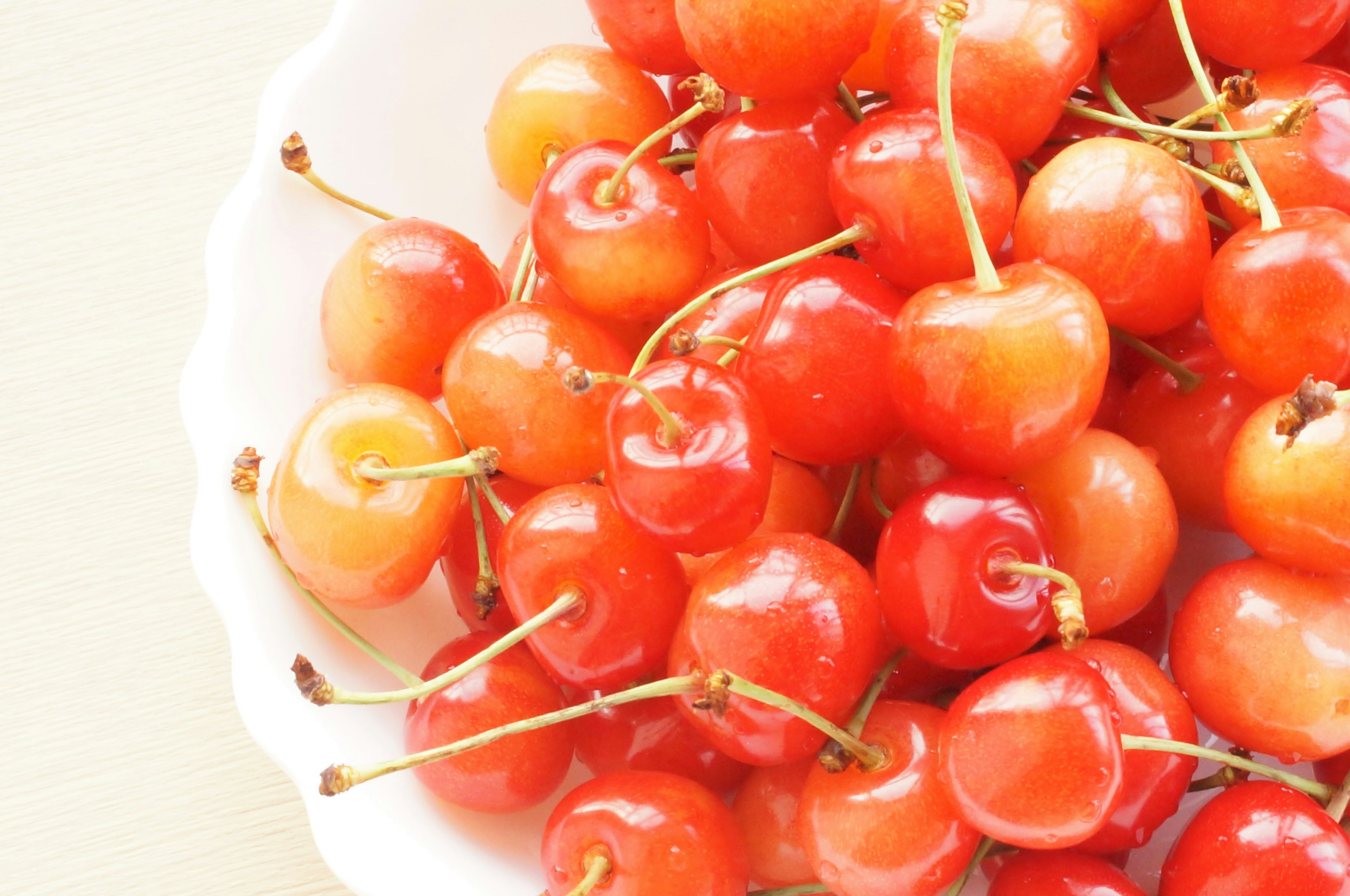 Un grupo de cerezas rojas y amarillas en un tazón blanco