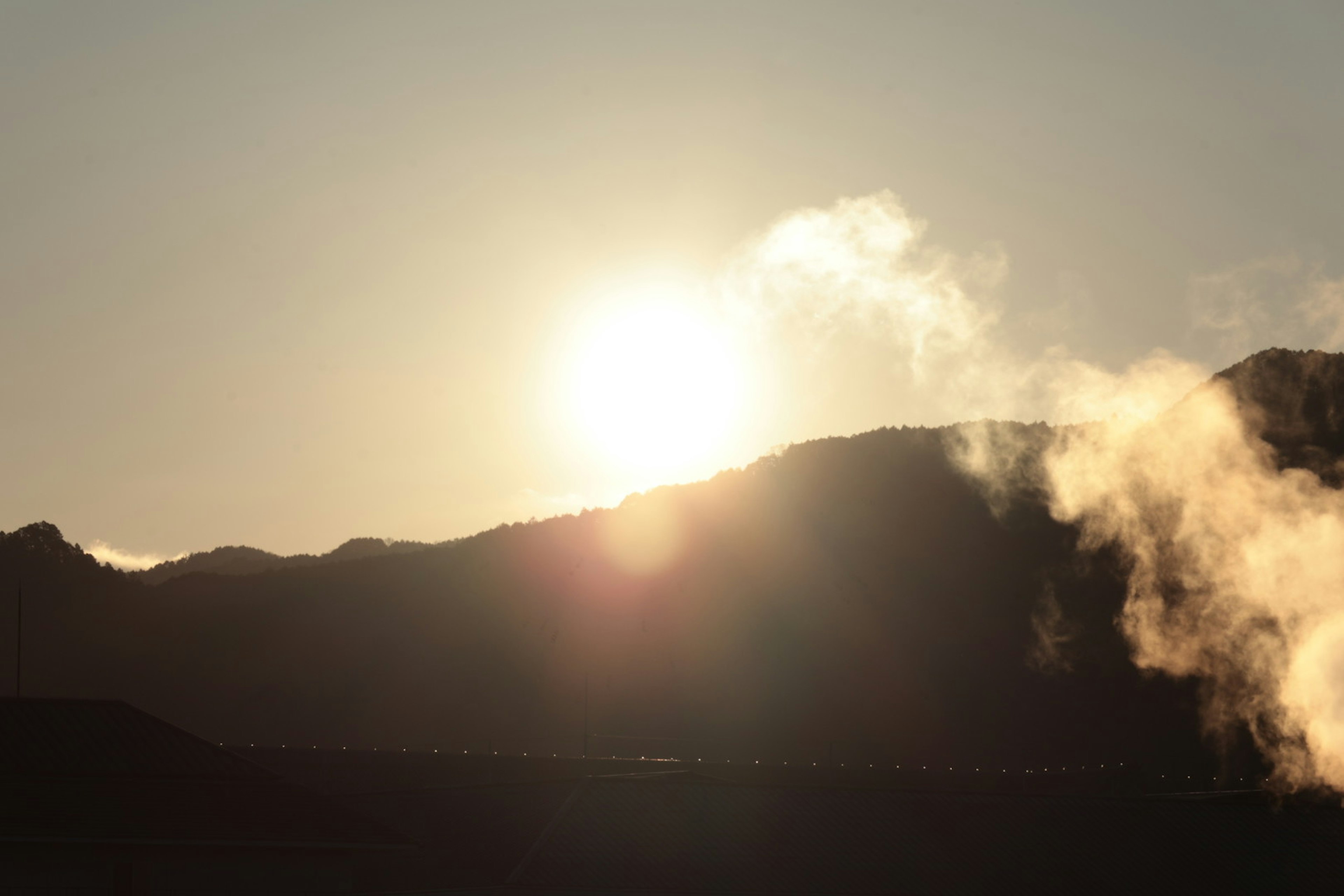 Lever de soleil derrière les montagnes avec de la vapeur