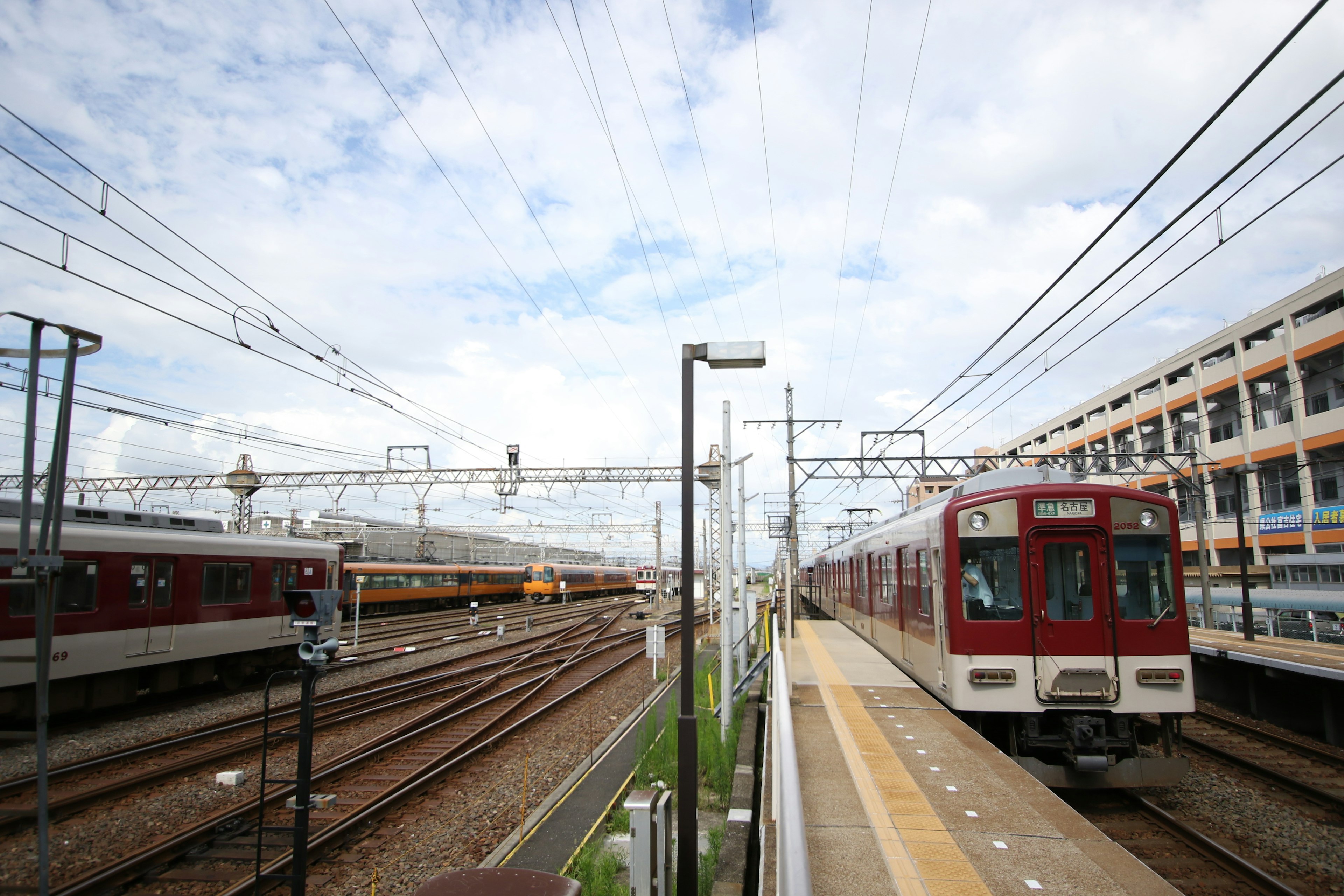 Blick auf einen Bahnhof mit einem roten Zug und mehreren Gleisen