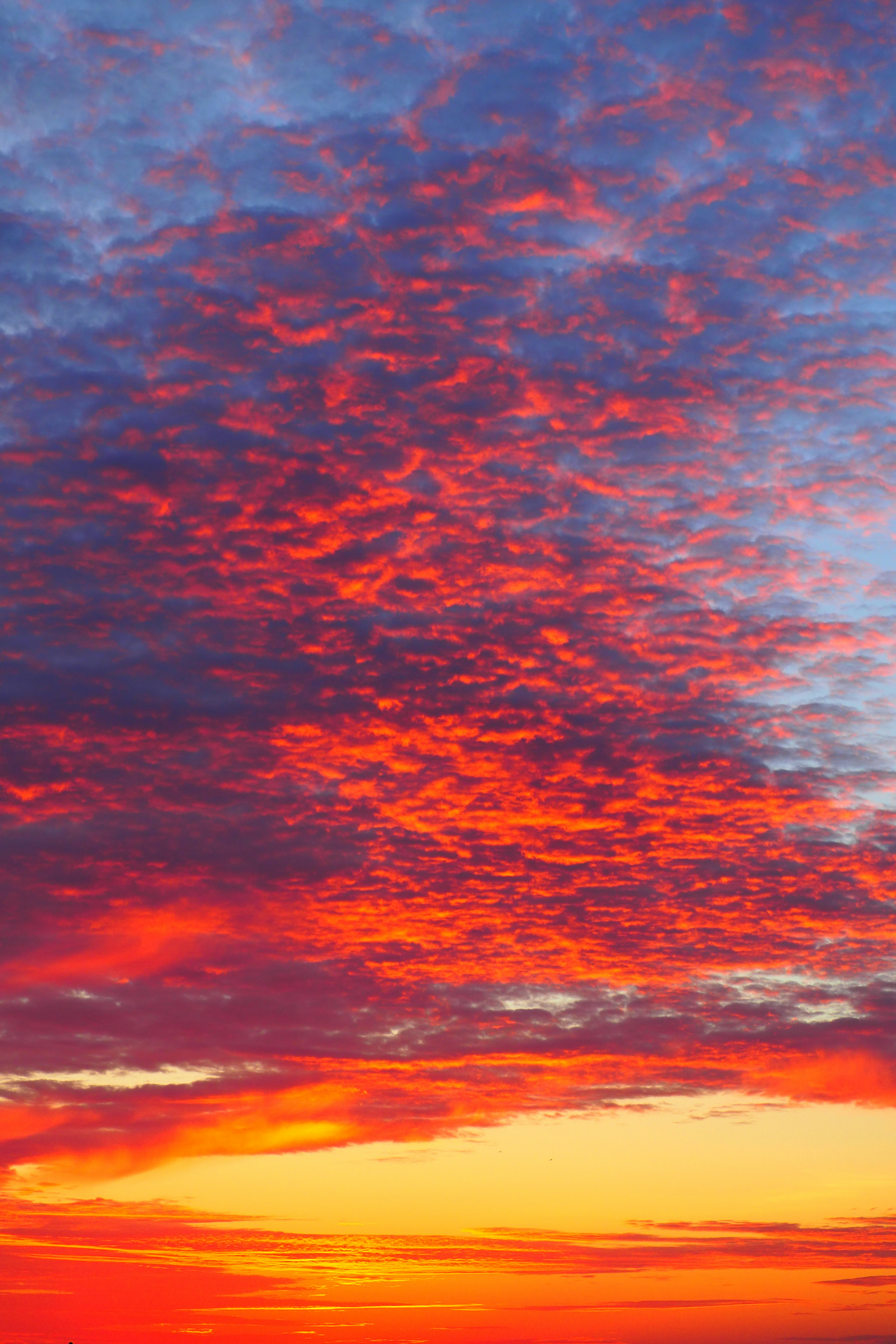 A stunning sky filled with clouds glowing in red and orange hues during sunset