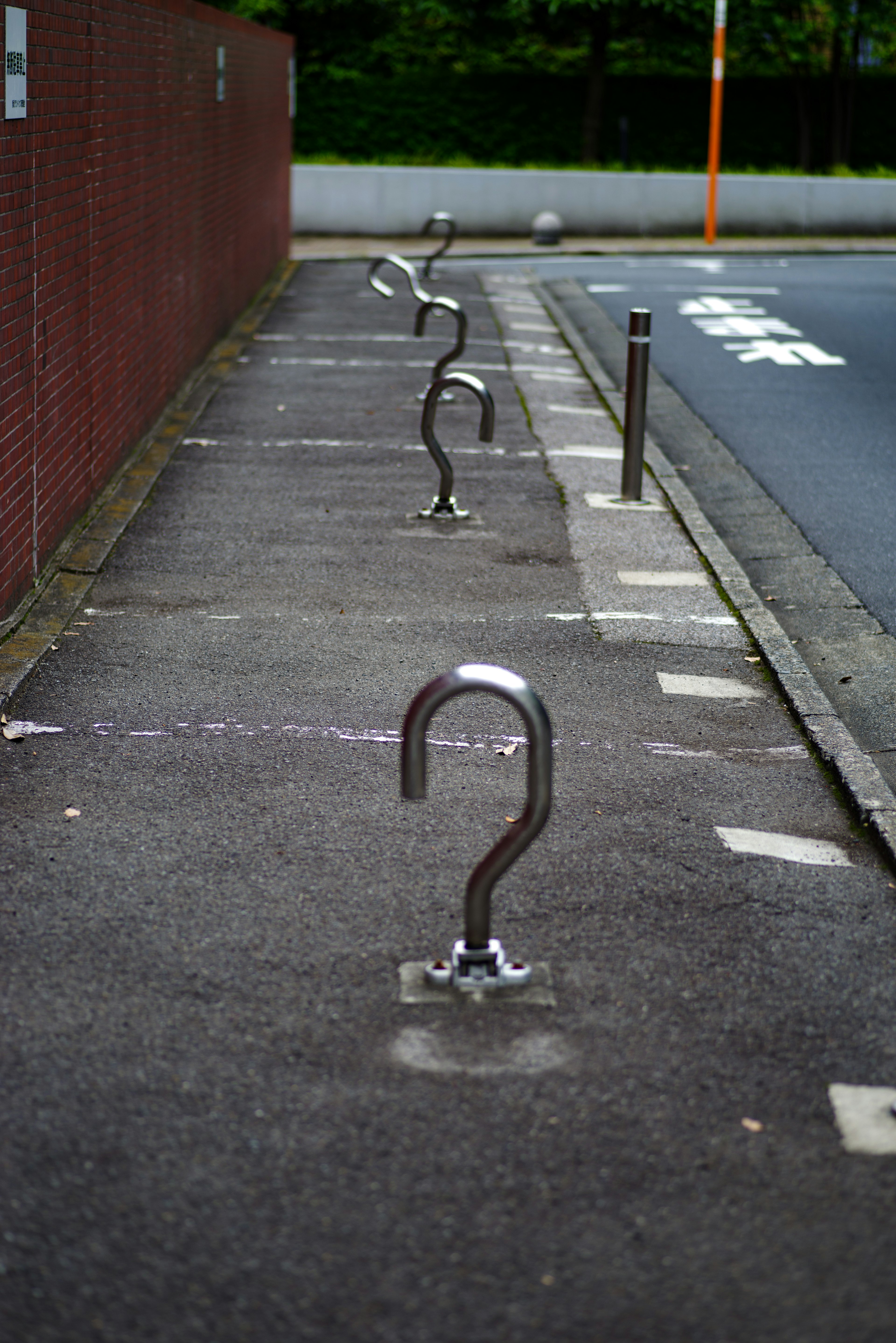 Unique shaped bicycle racks lined along a paved pathway