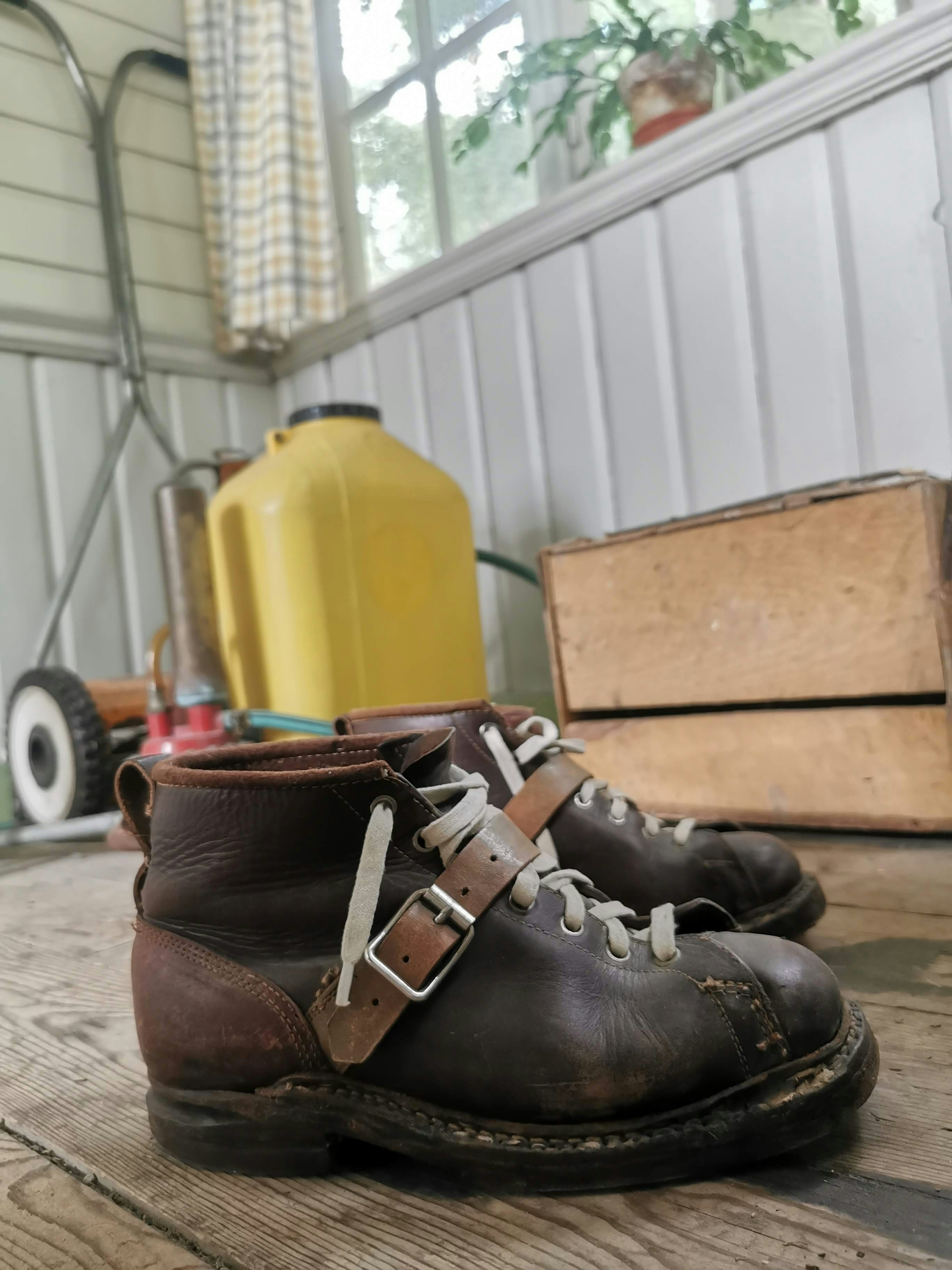 Vecchie scarpe marroni e una scatola di legno in un ambiente interno