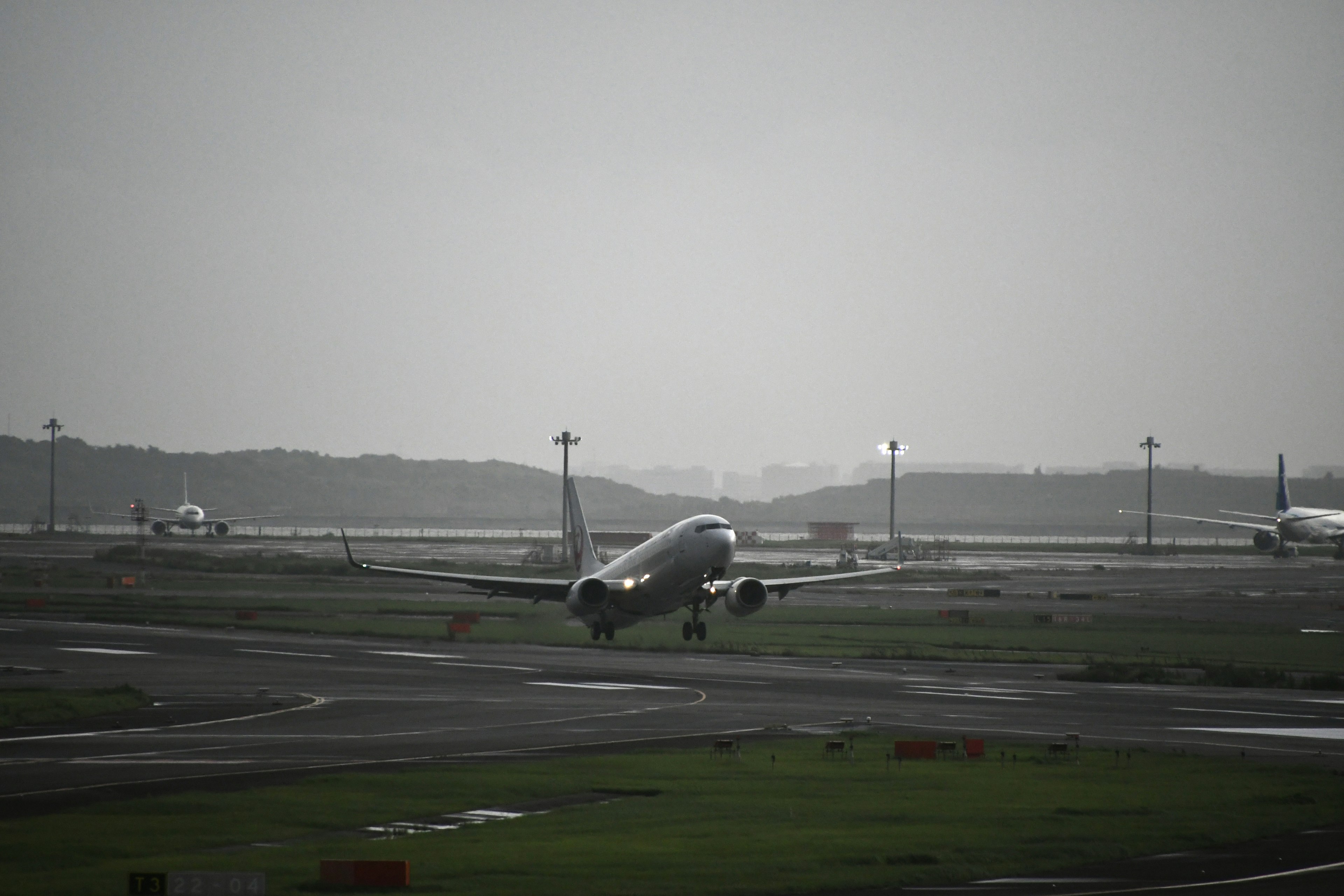 Airplane landing on runway under overcast sky