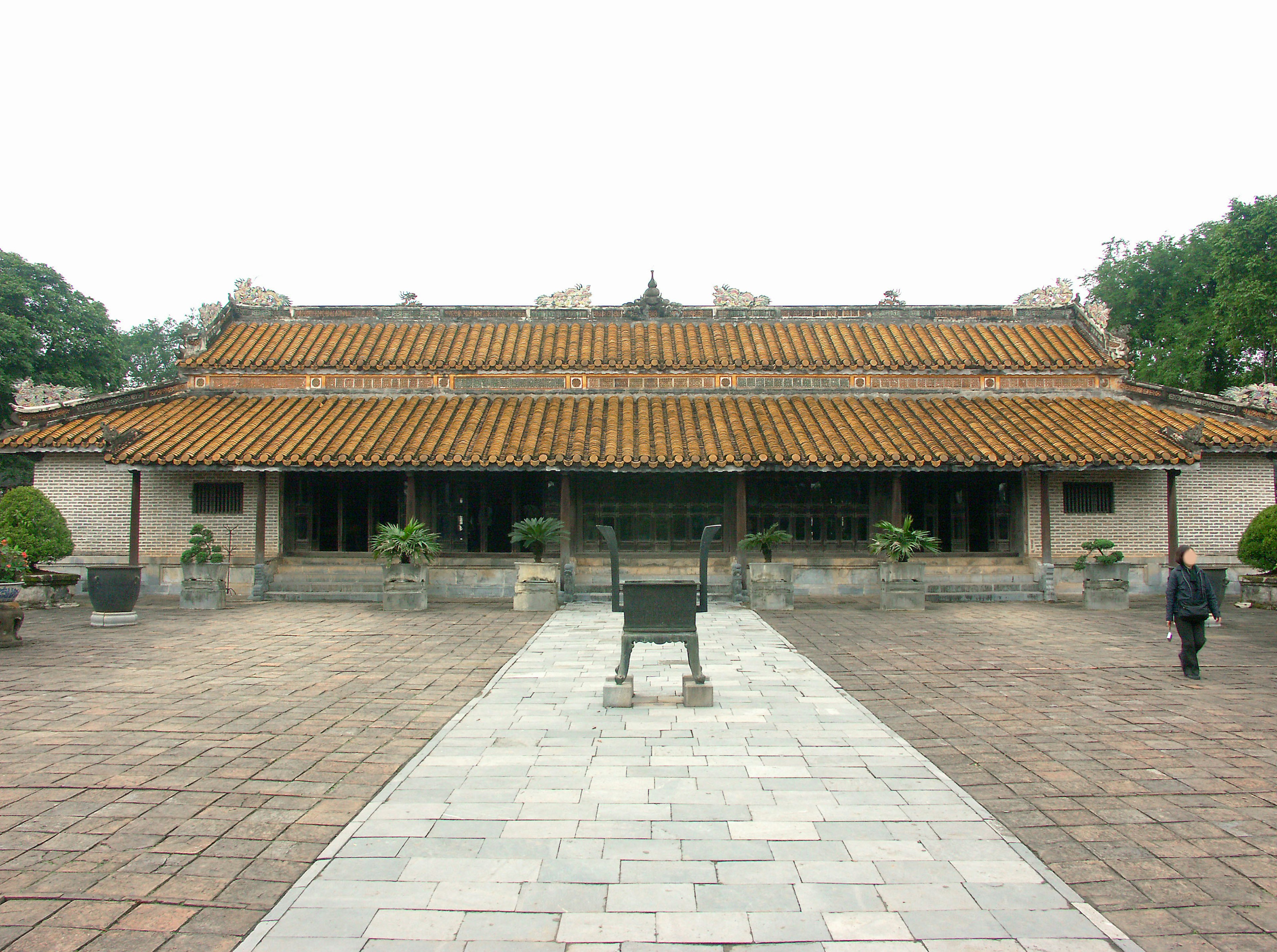 A courtyard featuring a traditional building with a tiled roof