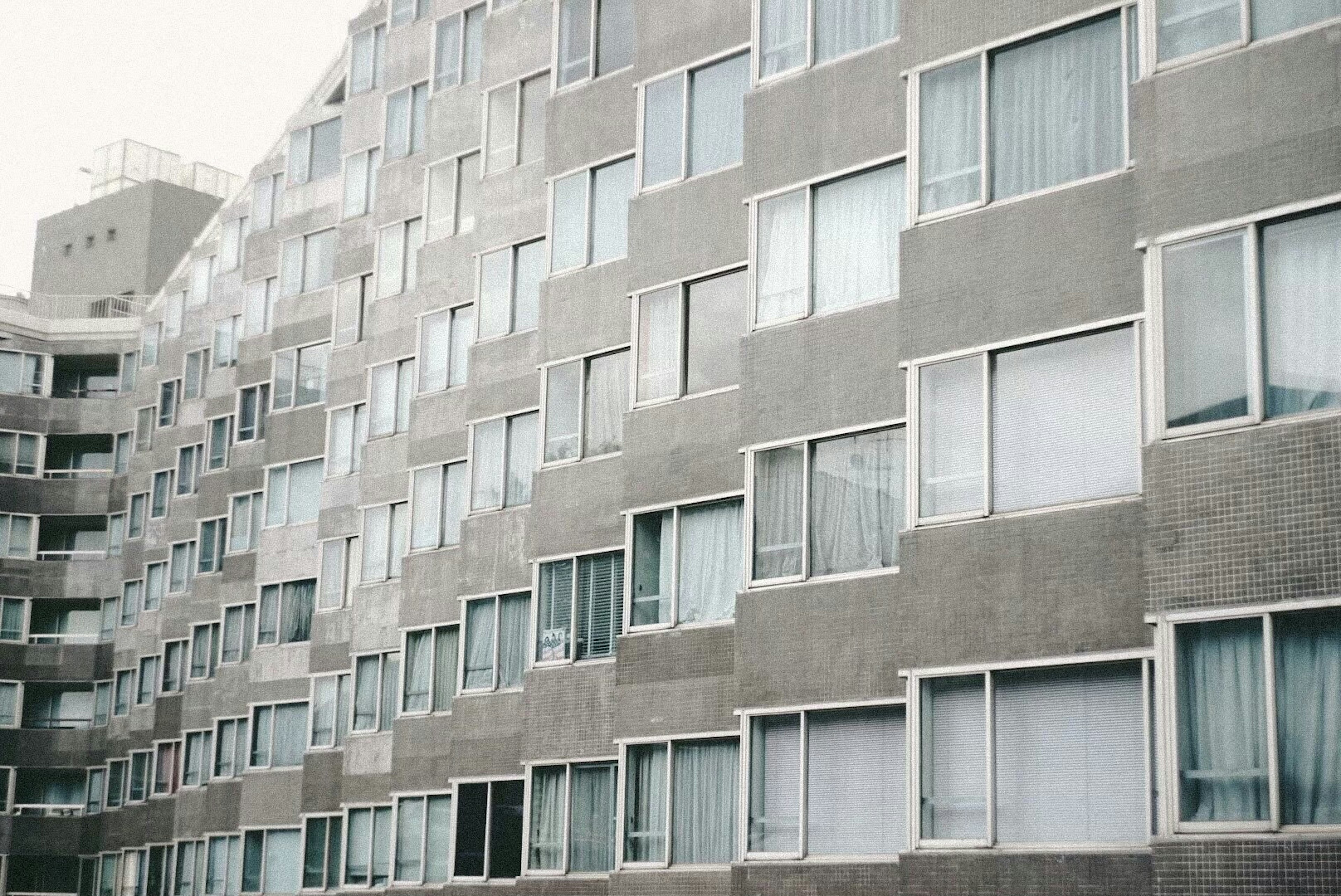 Facade of a modern apartment building featuring windows and concrete design