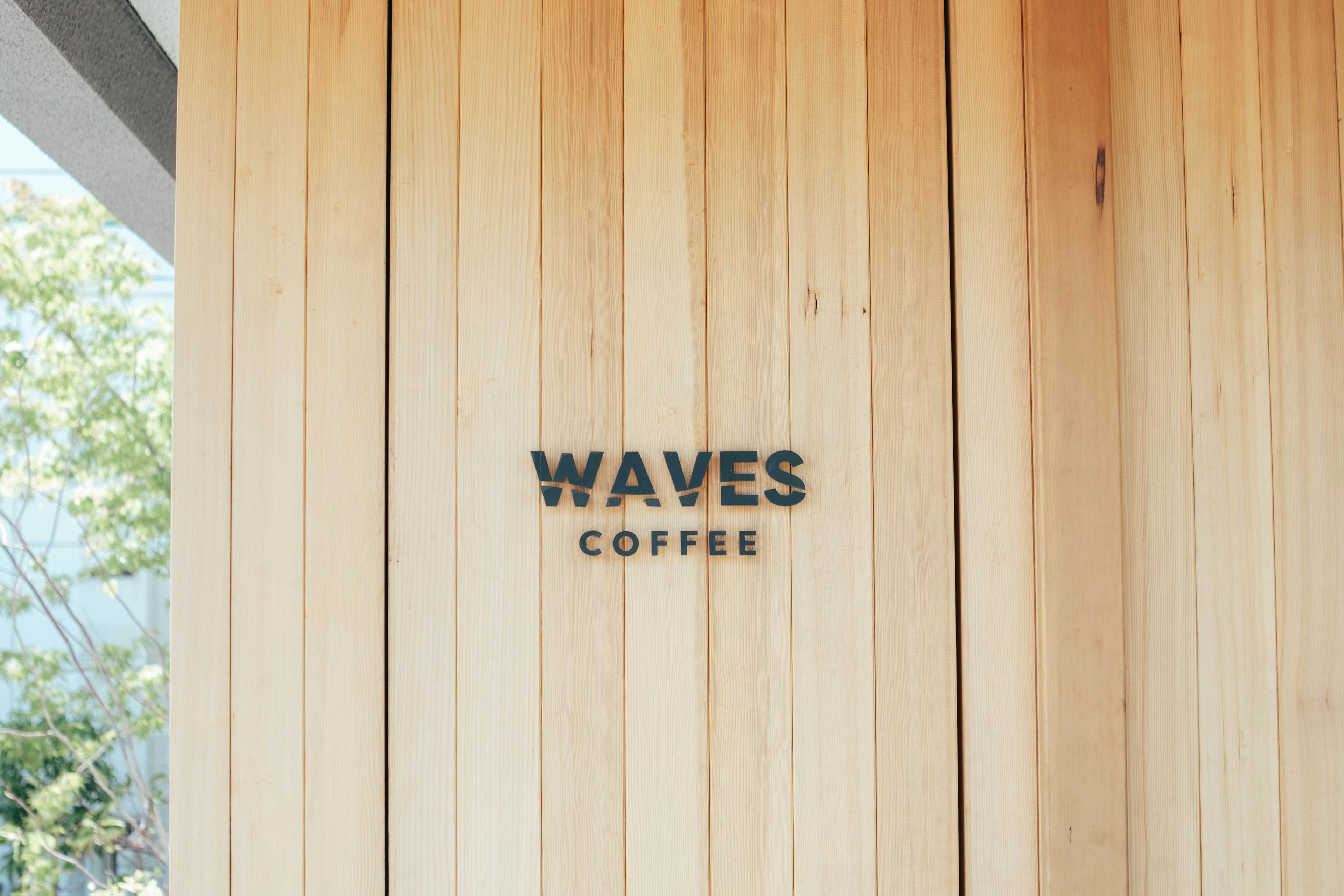 Tanda WAVES COFFEE di dinding panel kayu