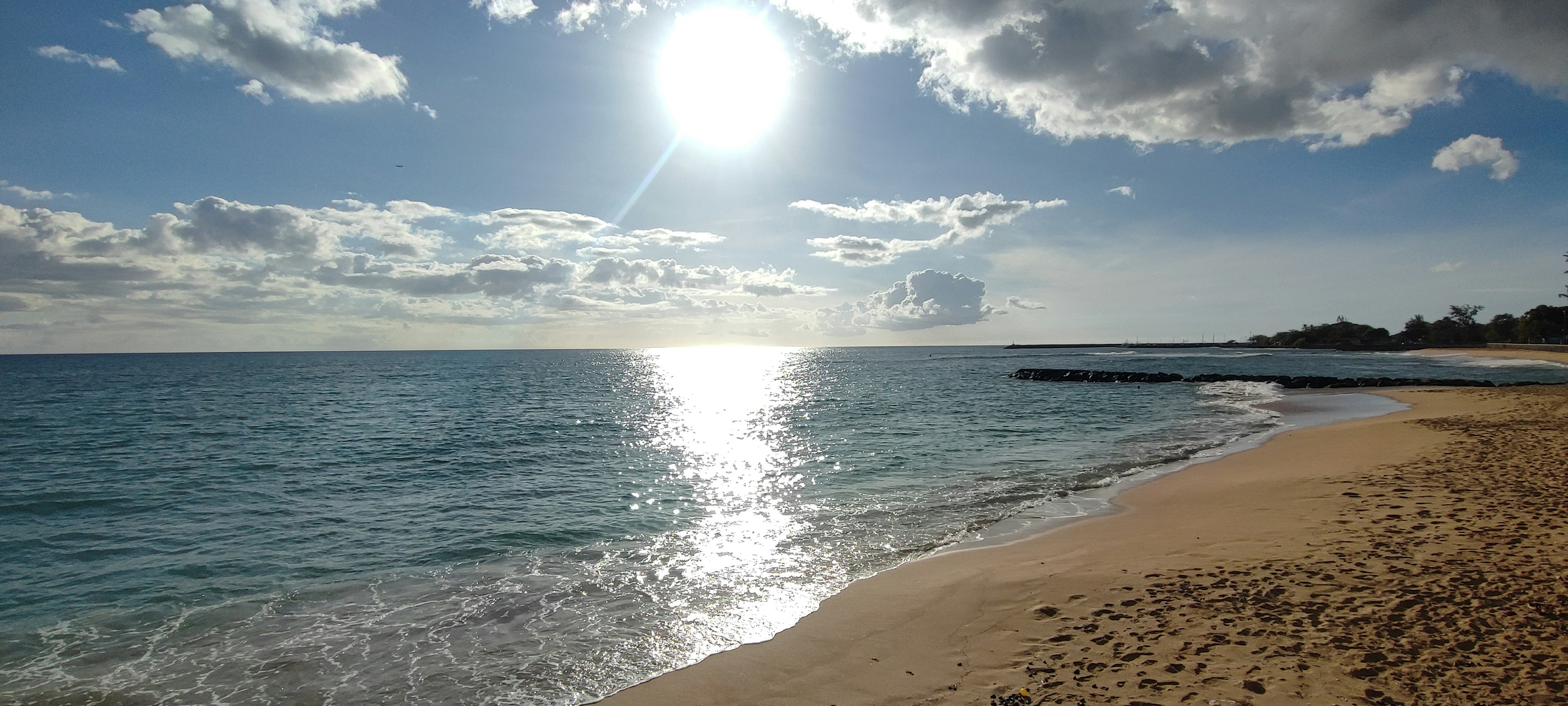 Soleil brillant sur une plage tranquille avec mer bleue et sable doré