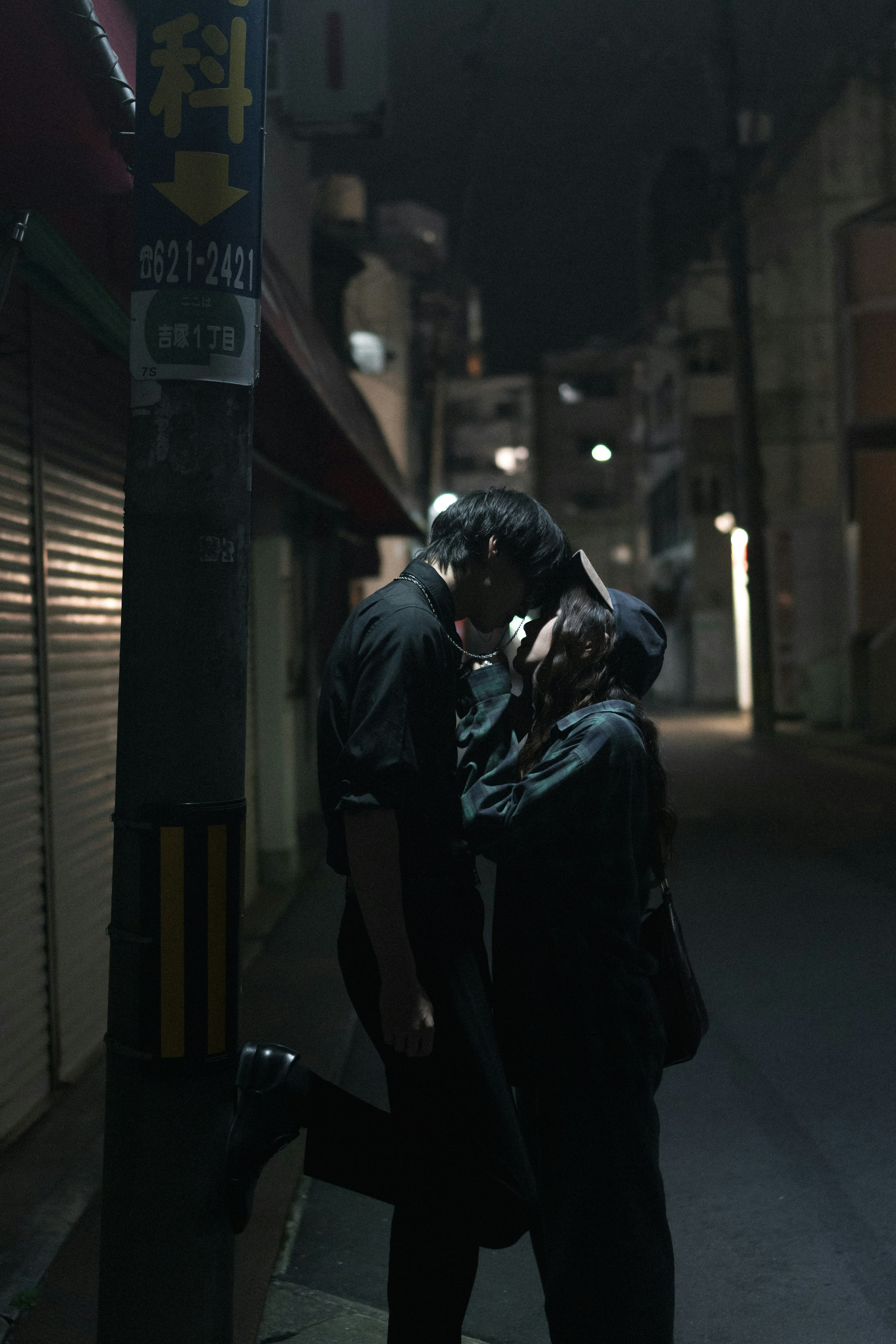 Silhouette d'un couple s'embrassant dans une ruelle sombre