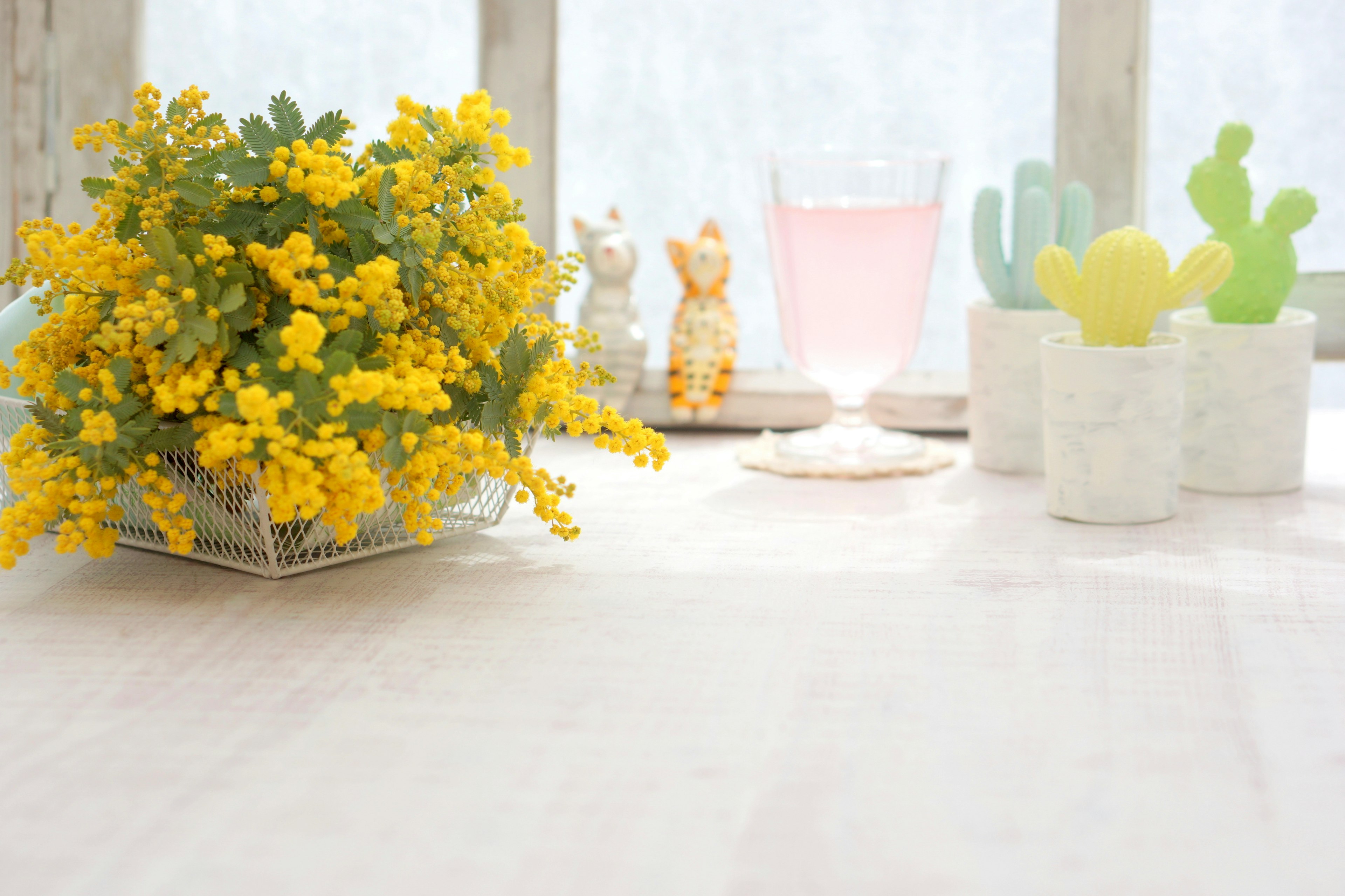 Una configuración de mesa tranquila con un ramo de flores amarillas y plantas en macetas coloridas