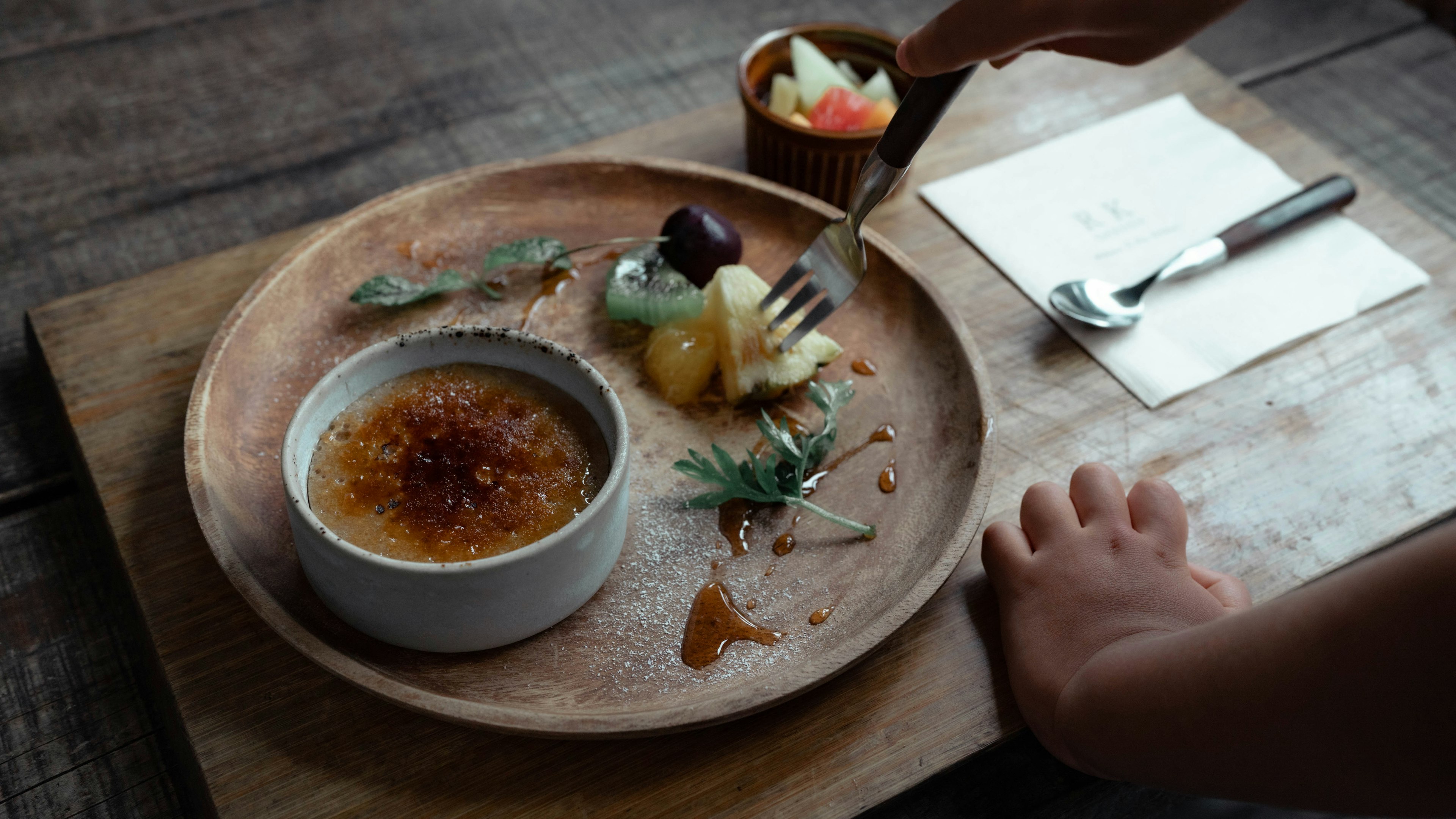 Plato de postre con crème brûlée y frutas variadas