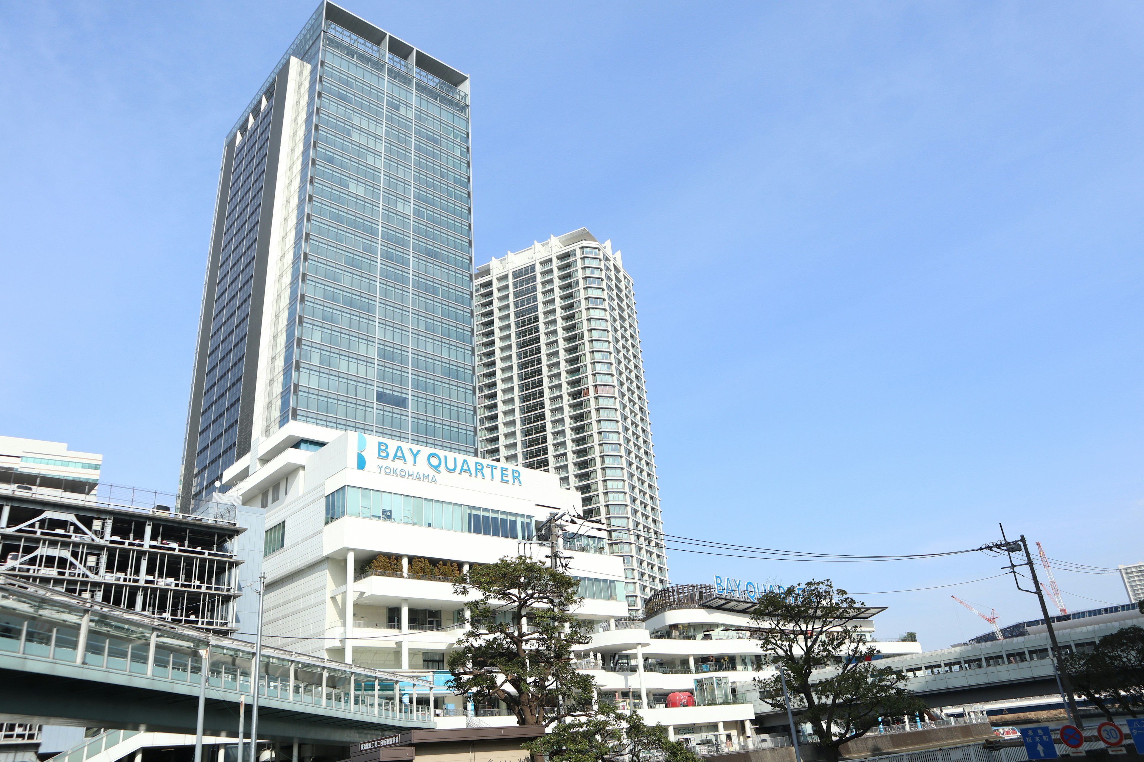 Modern buildings with glass facades and a clear blue sky featuring commercial spaces