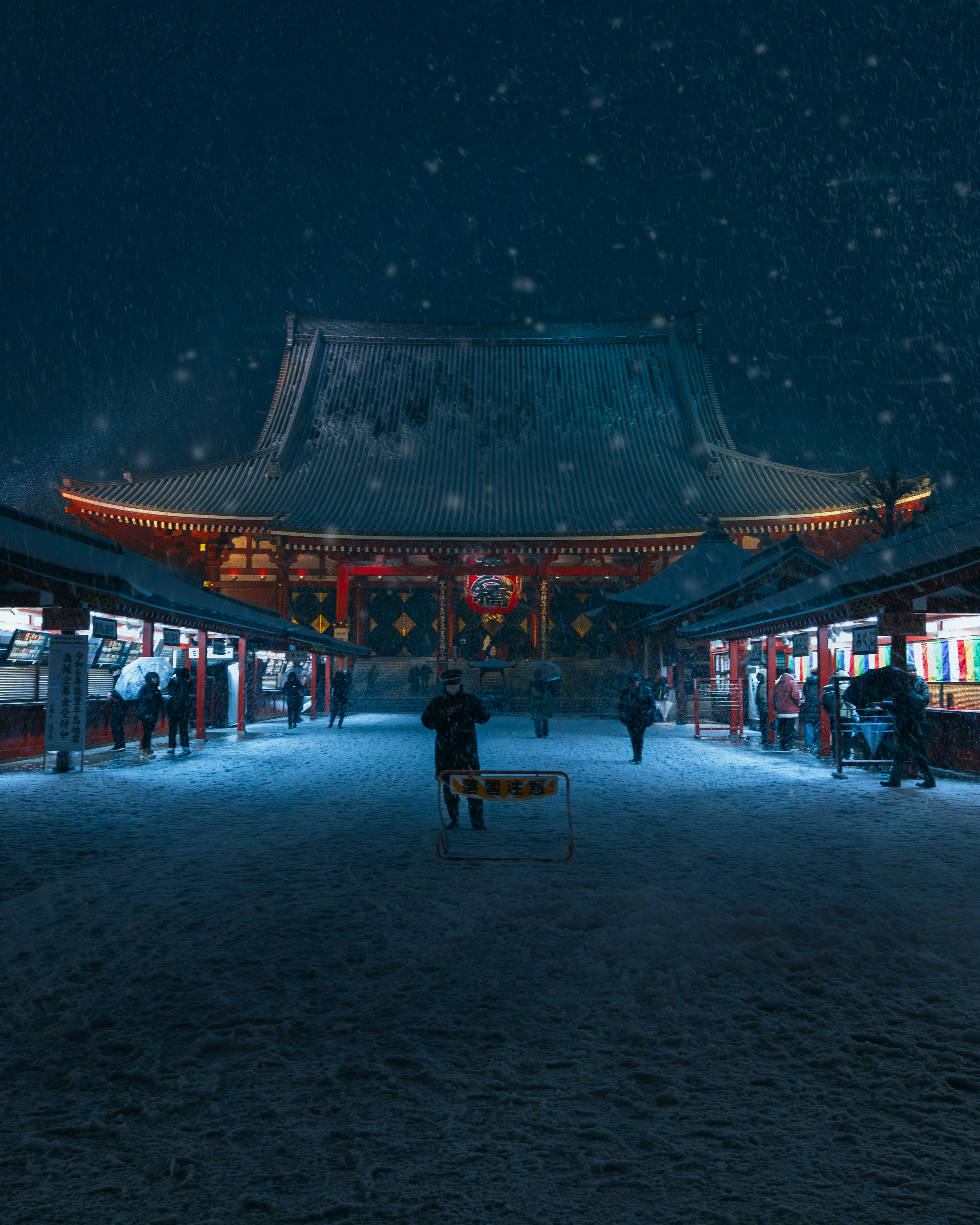 雪中照亮的神社门和小径