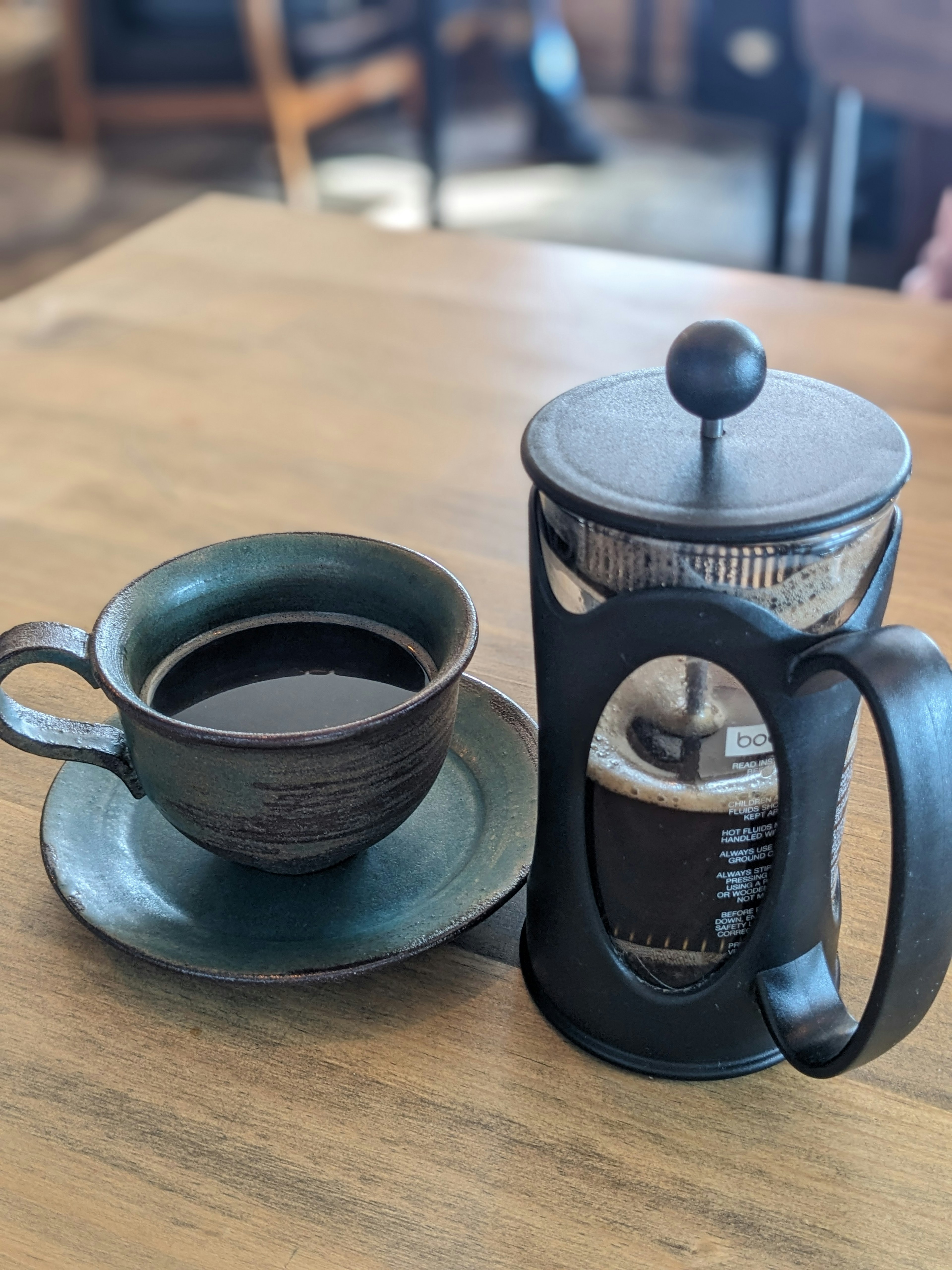 Presse française et tasse de café sur une table en bois