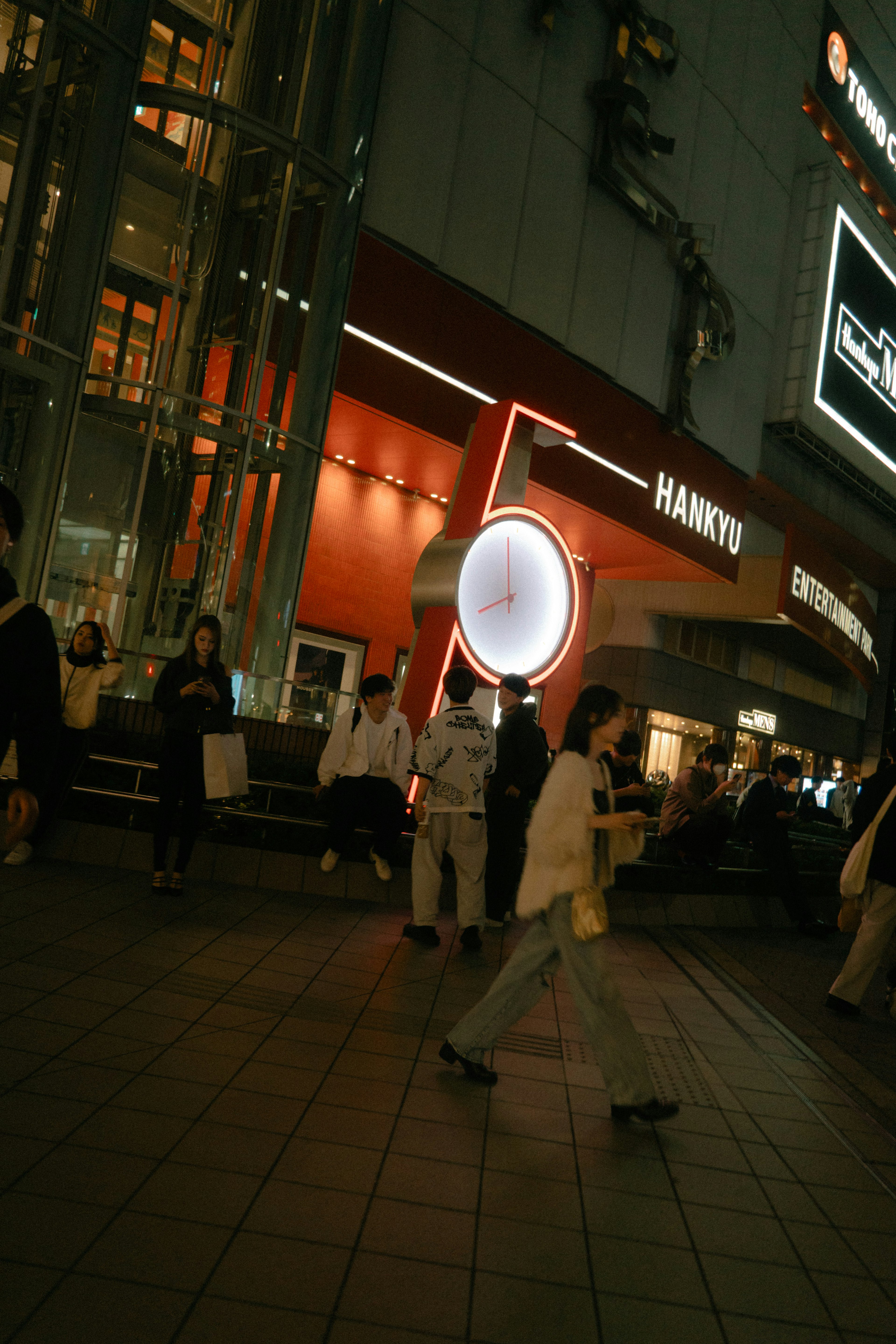 夜の街角で歩く人々と照明が印象的な風景