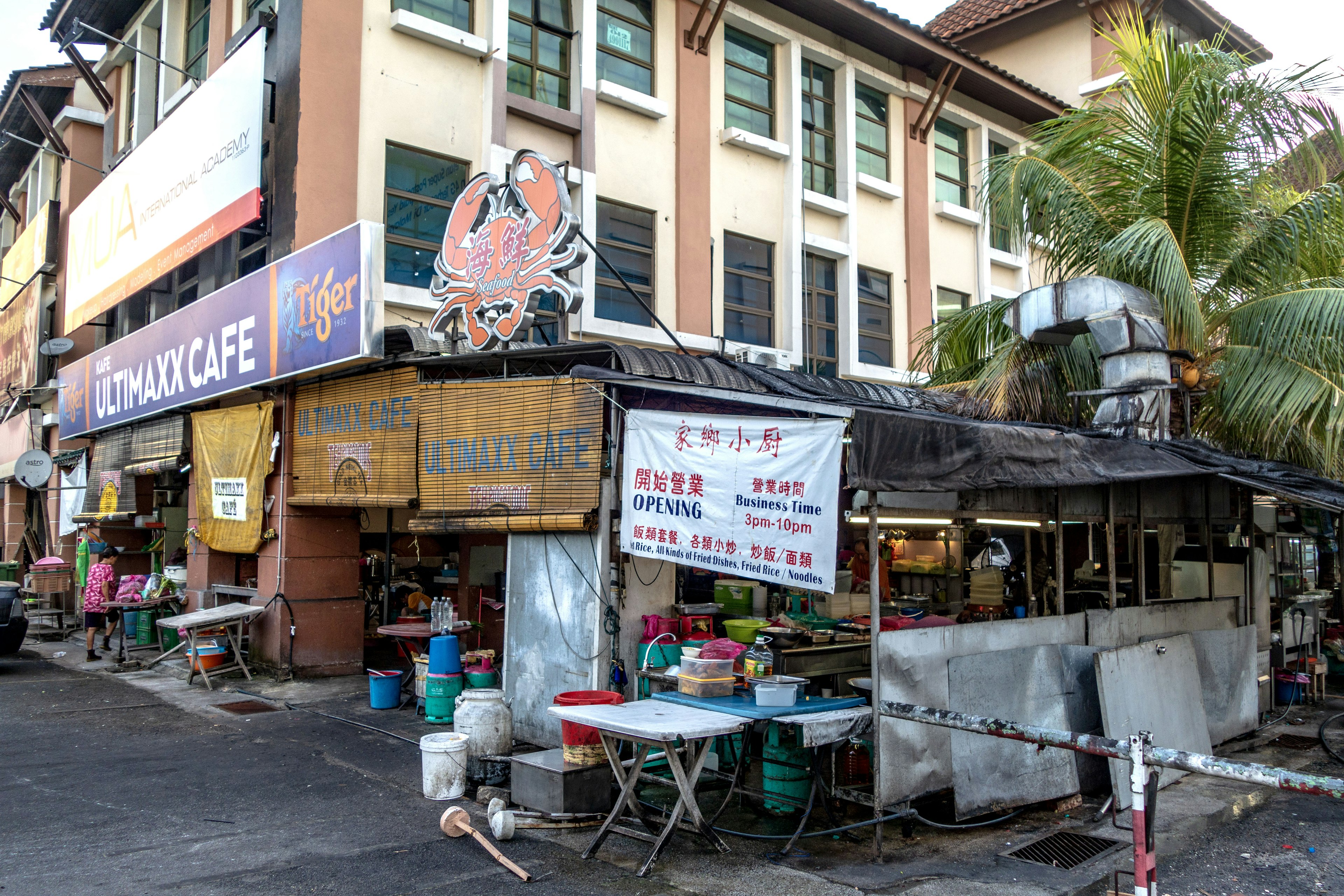 ทิวทัศน์ถนนของคาเฟ่พร้อมแผงขายอาหารและต้นปาล์ม