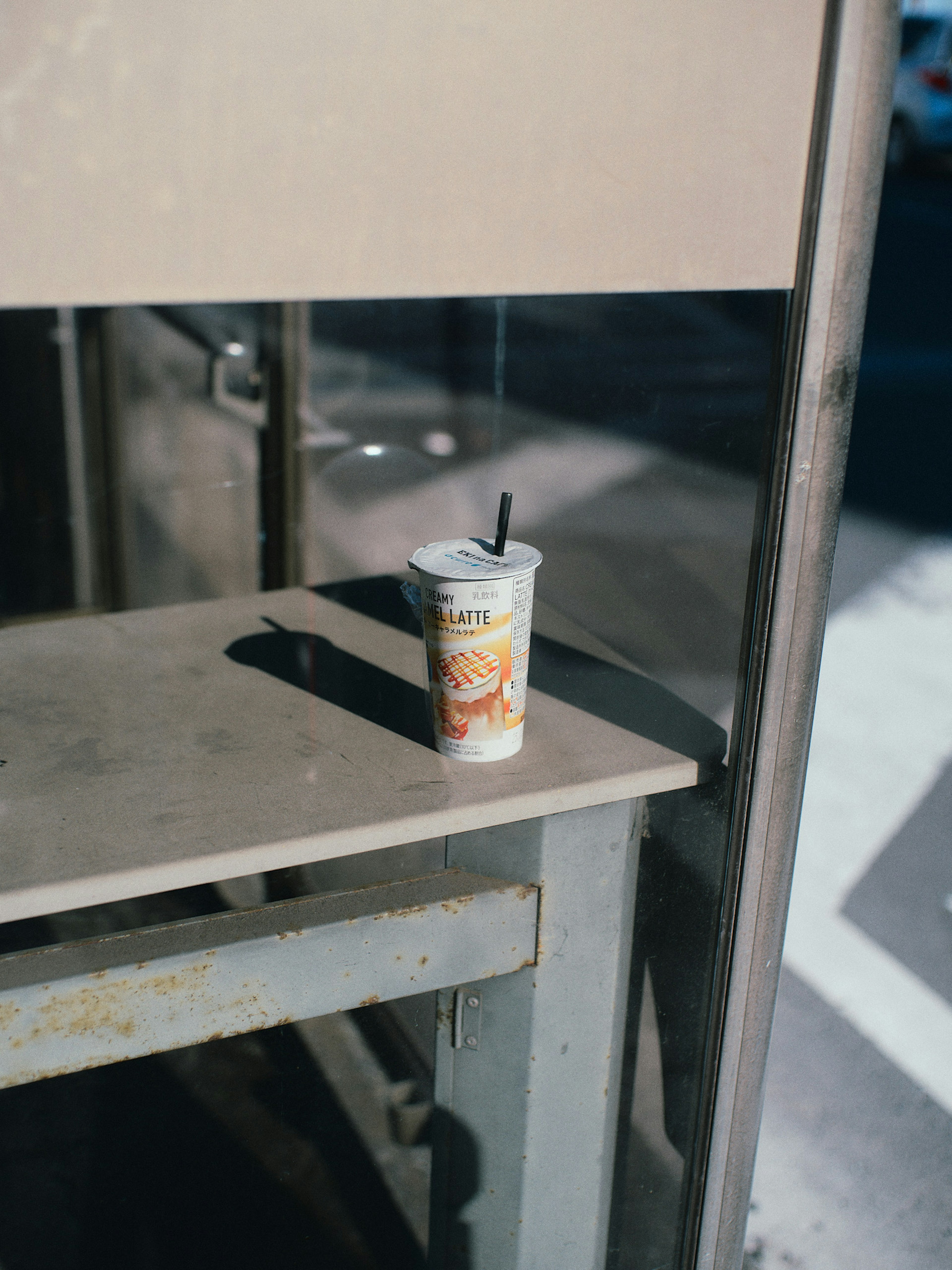 Colorful drink cup placed on a bus stop bench