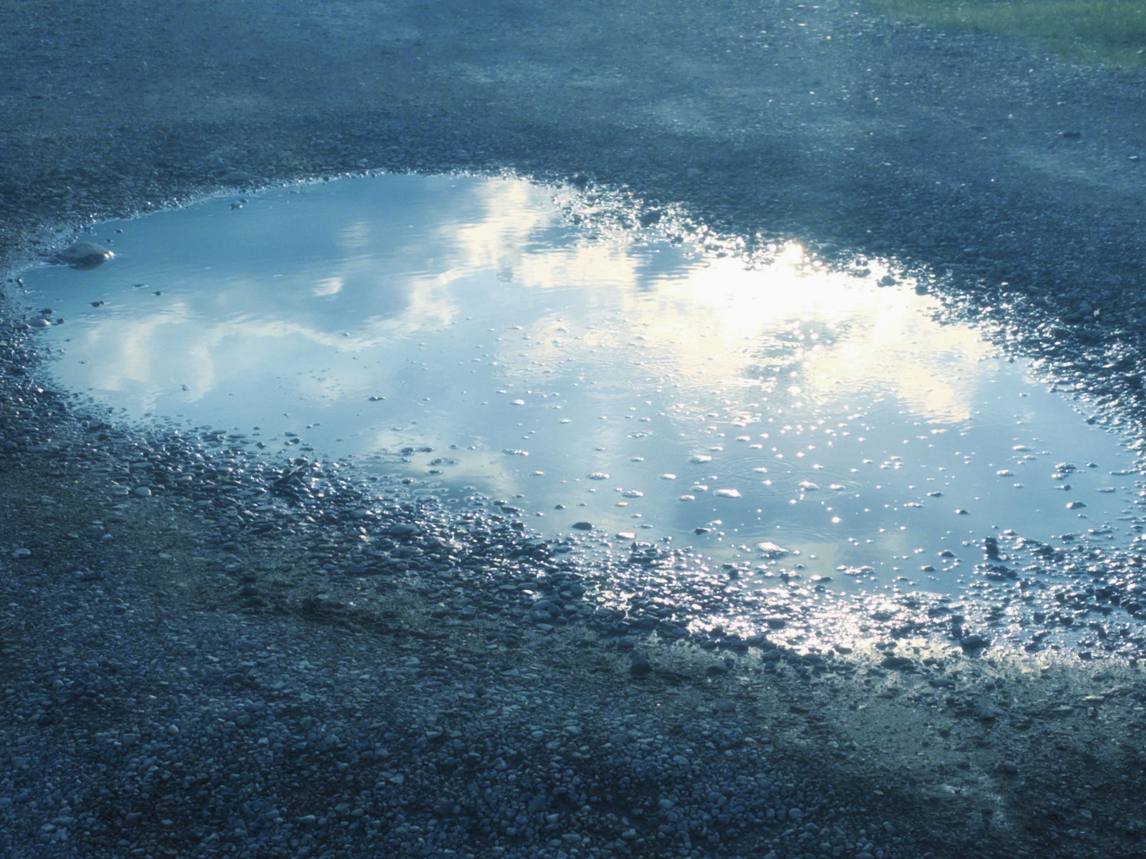 Reflet du ciel bleu et des nuages dans une flaque d'eau