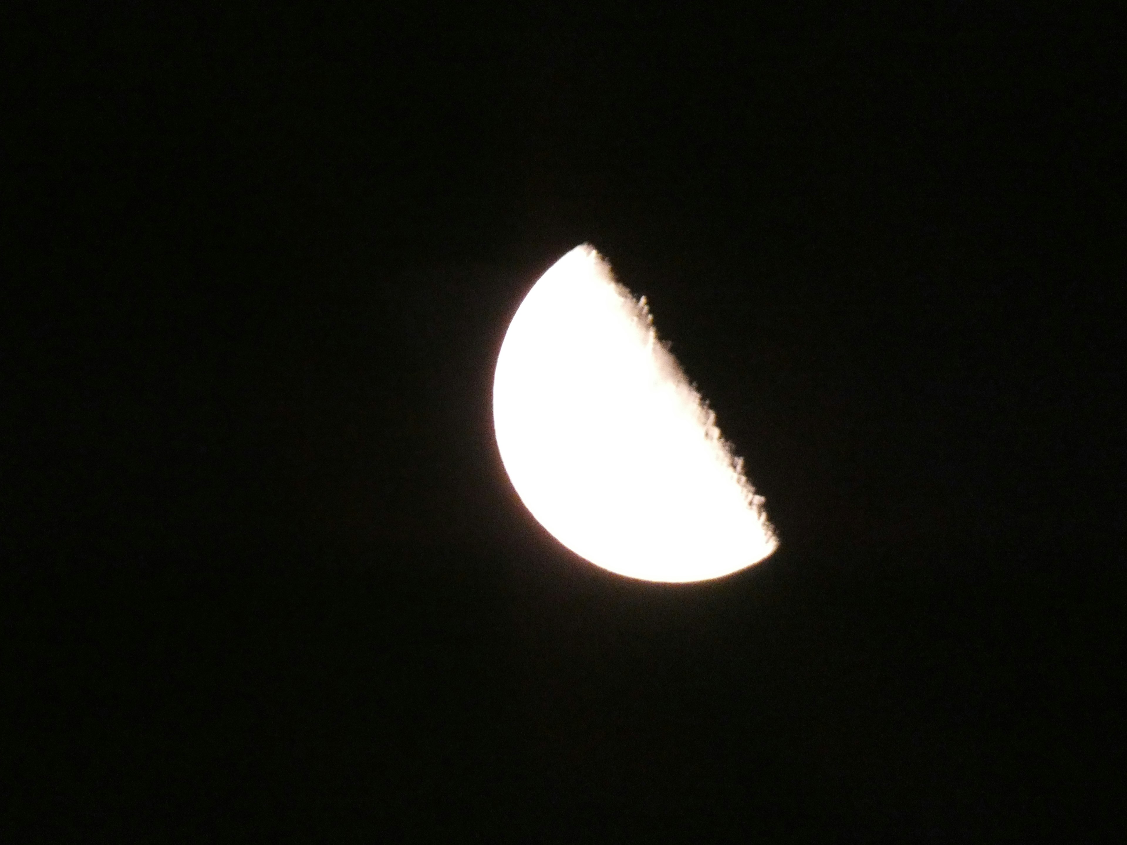 Luna mezza illuminata contro un cielo notturno scuro