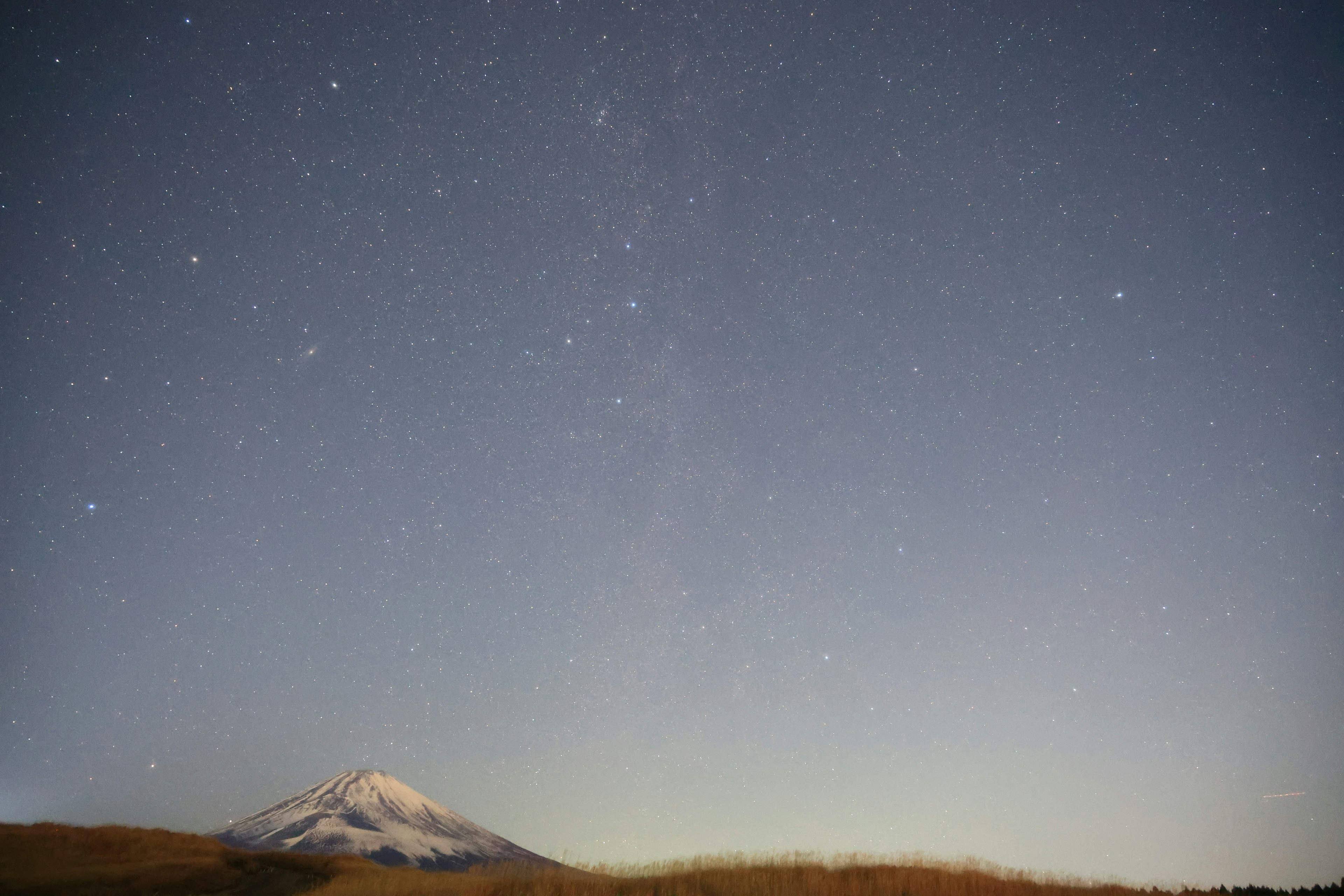 A beautiful landscape featuring a snow-capped mountain and a starry sky