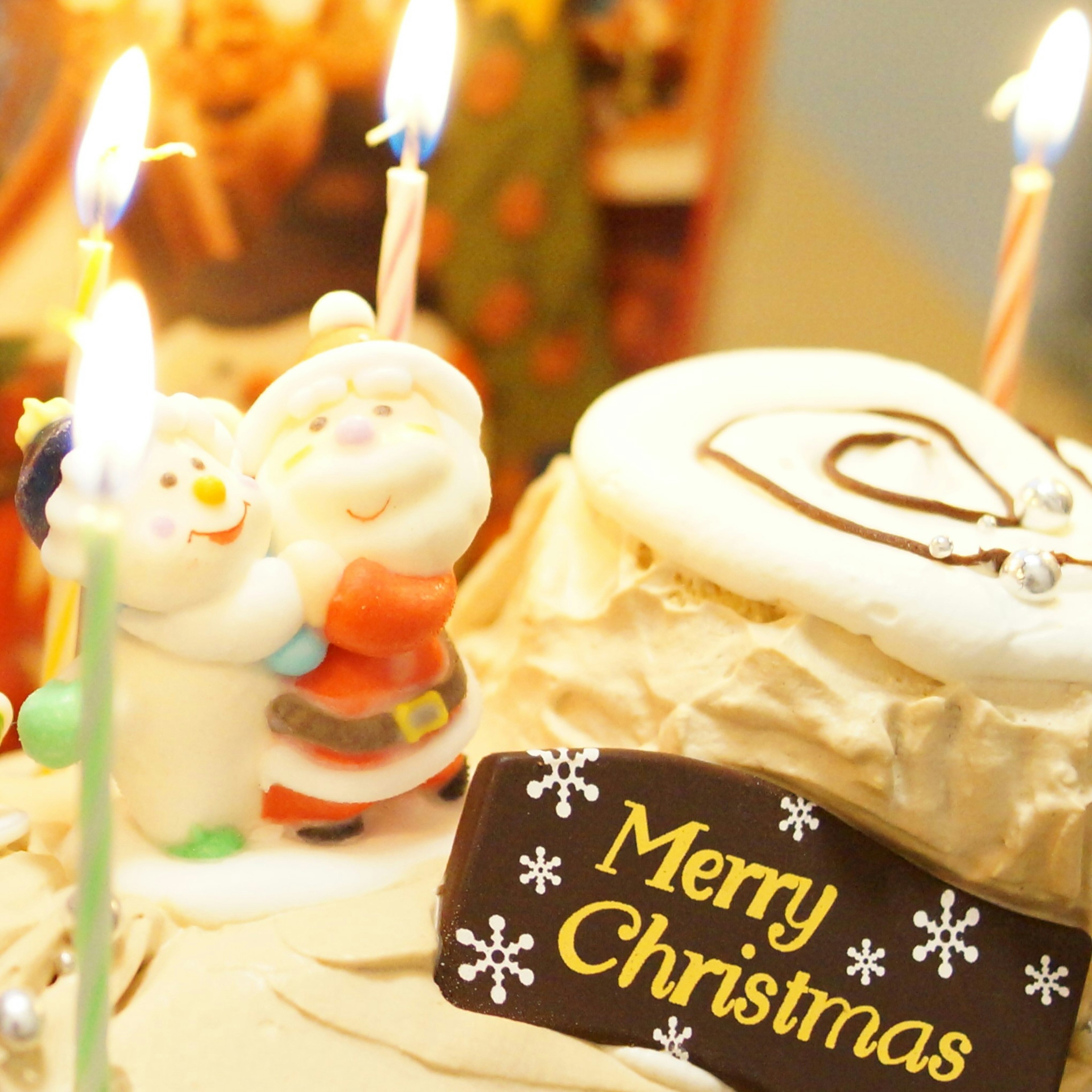 Christmas cake with candles and Santa figurine decoration