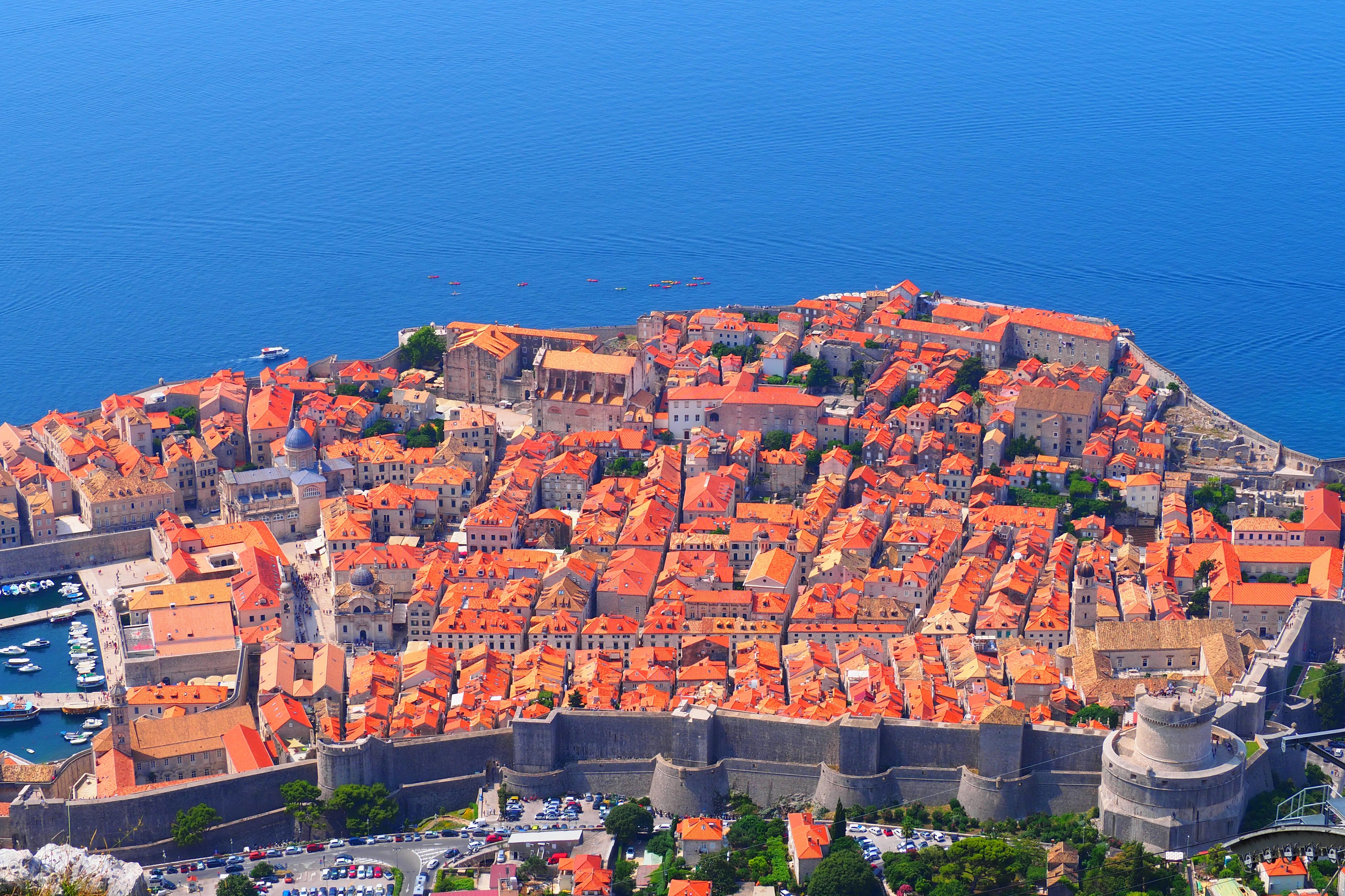 Luftaufnahme der Altstadt von Dubrovnik umgeben von Meer mit orangefarbenen Dächern