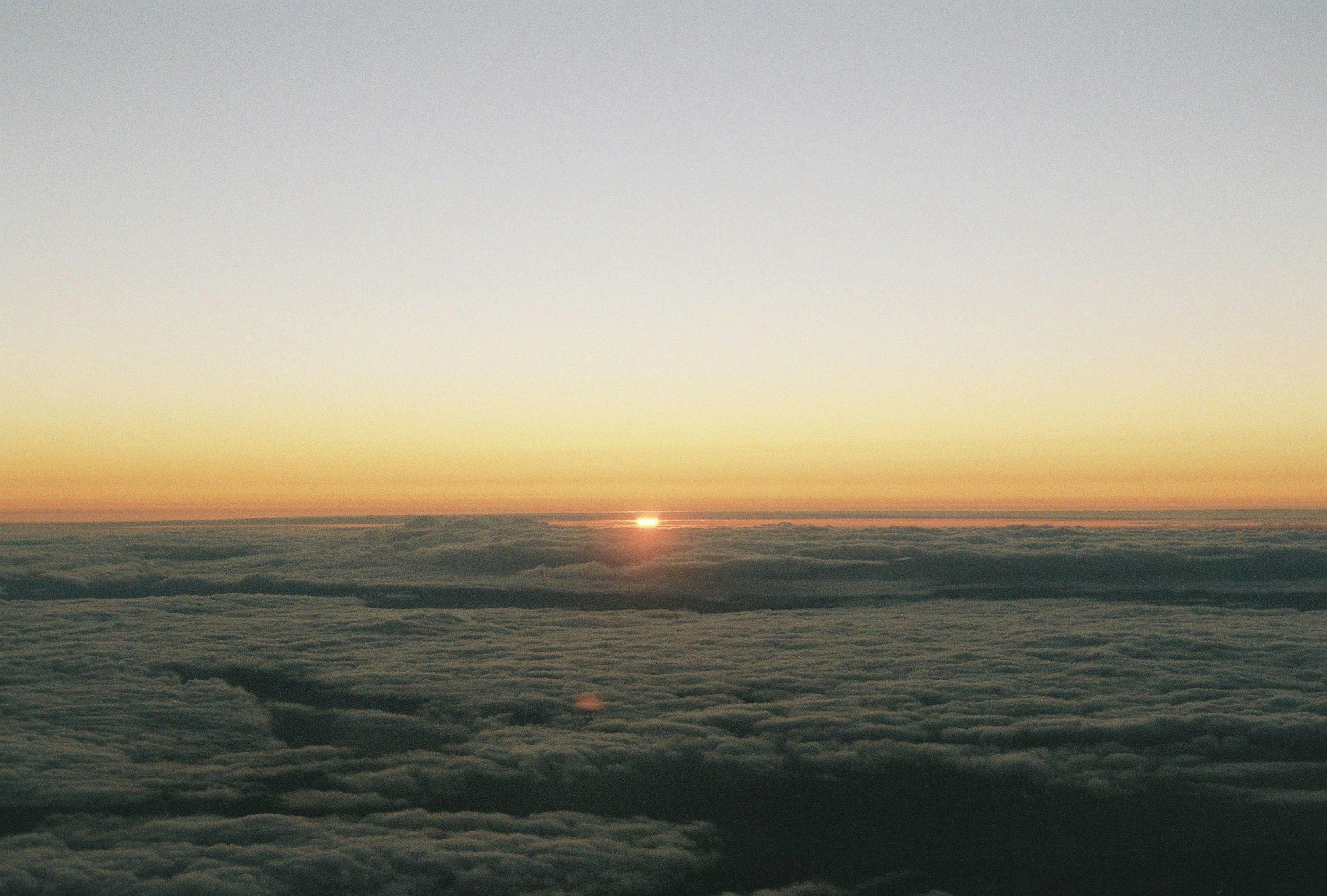 Amanecer sobre las nubes con un cielo naranja