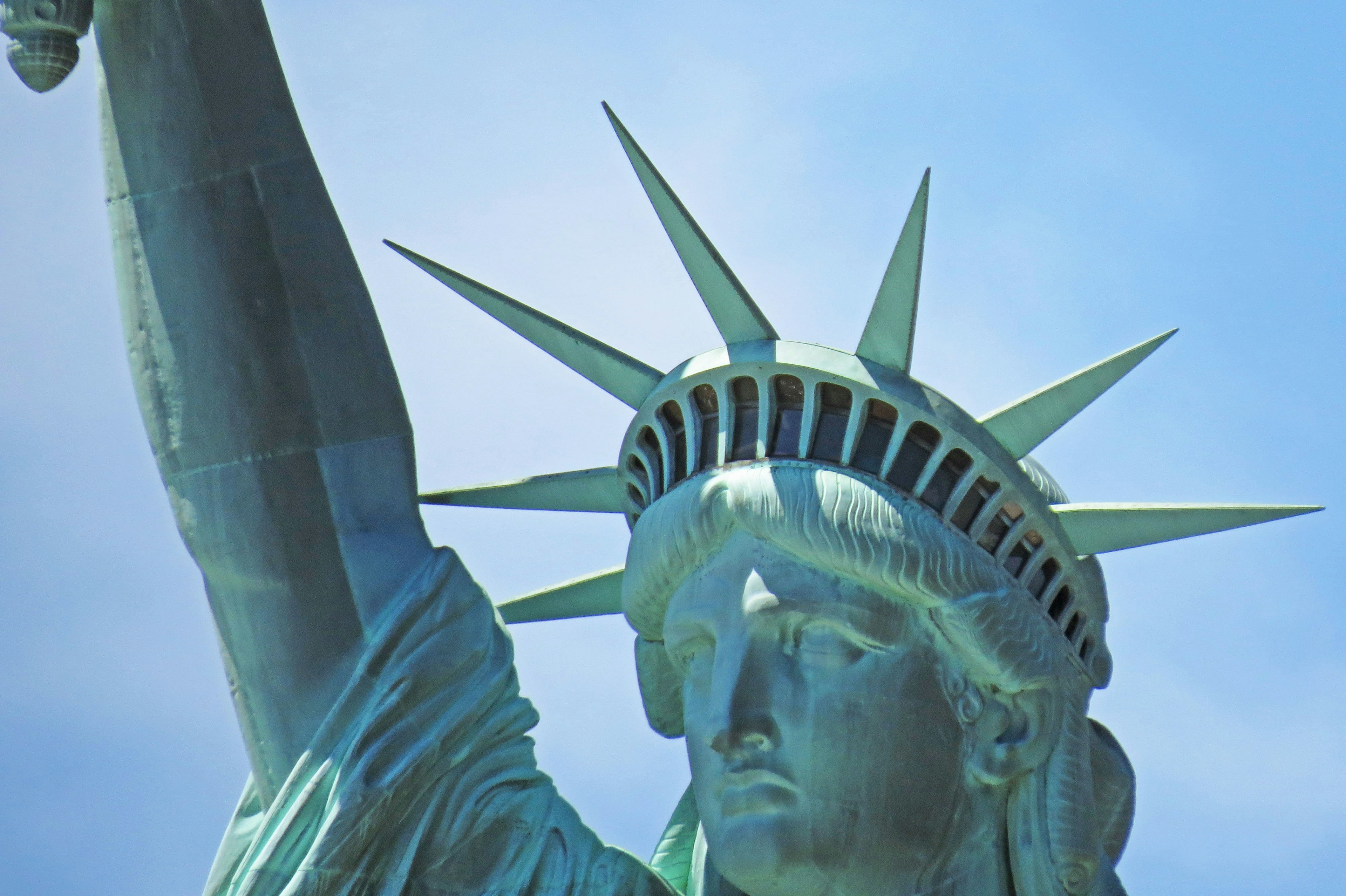 Close-up image of the Statue of Liberty Copper statue under a clear blue sky