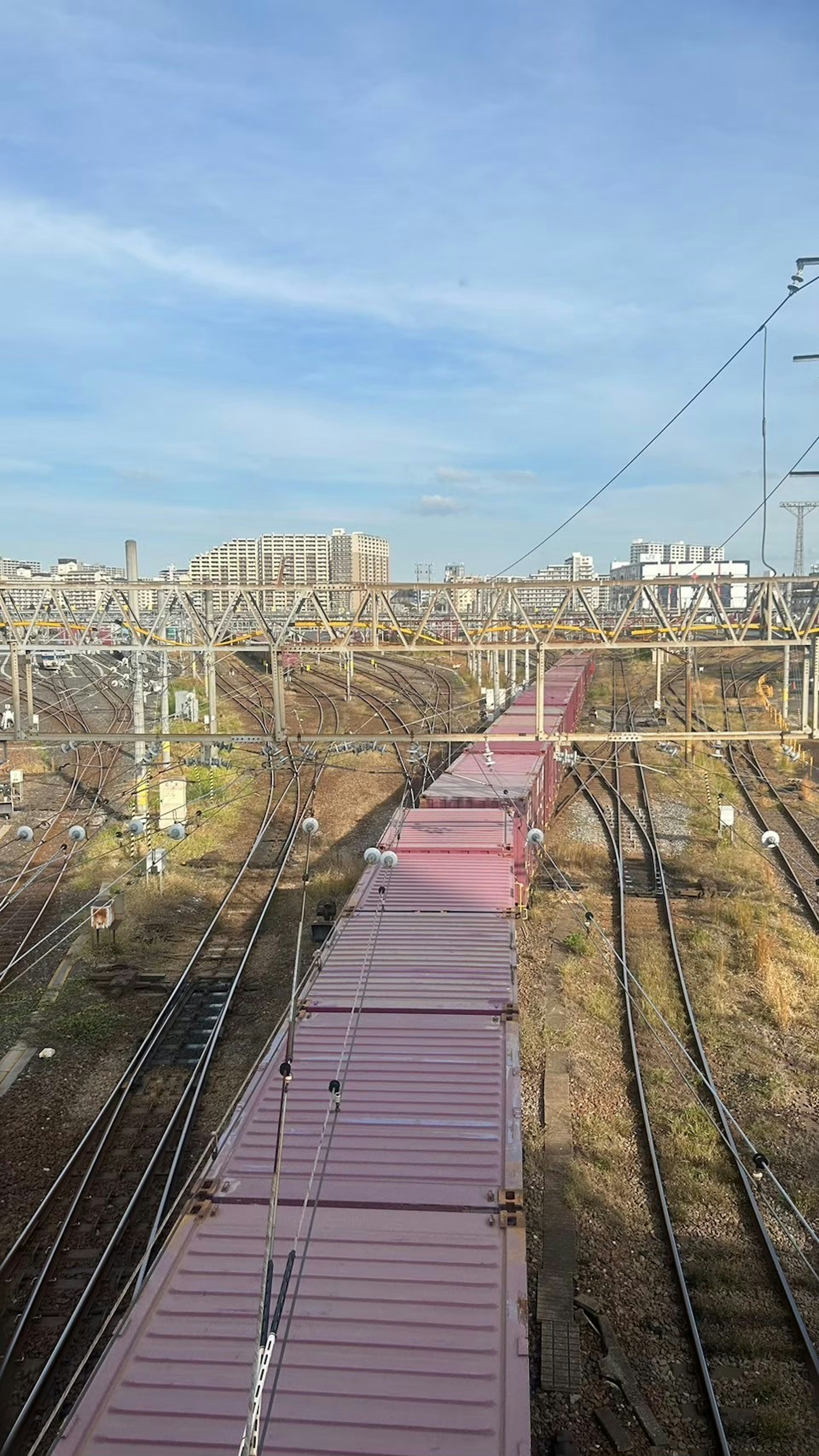 Vue d'un train de marchandises sur des voies ferrées avec une infrastructure environnante