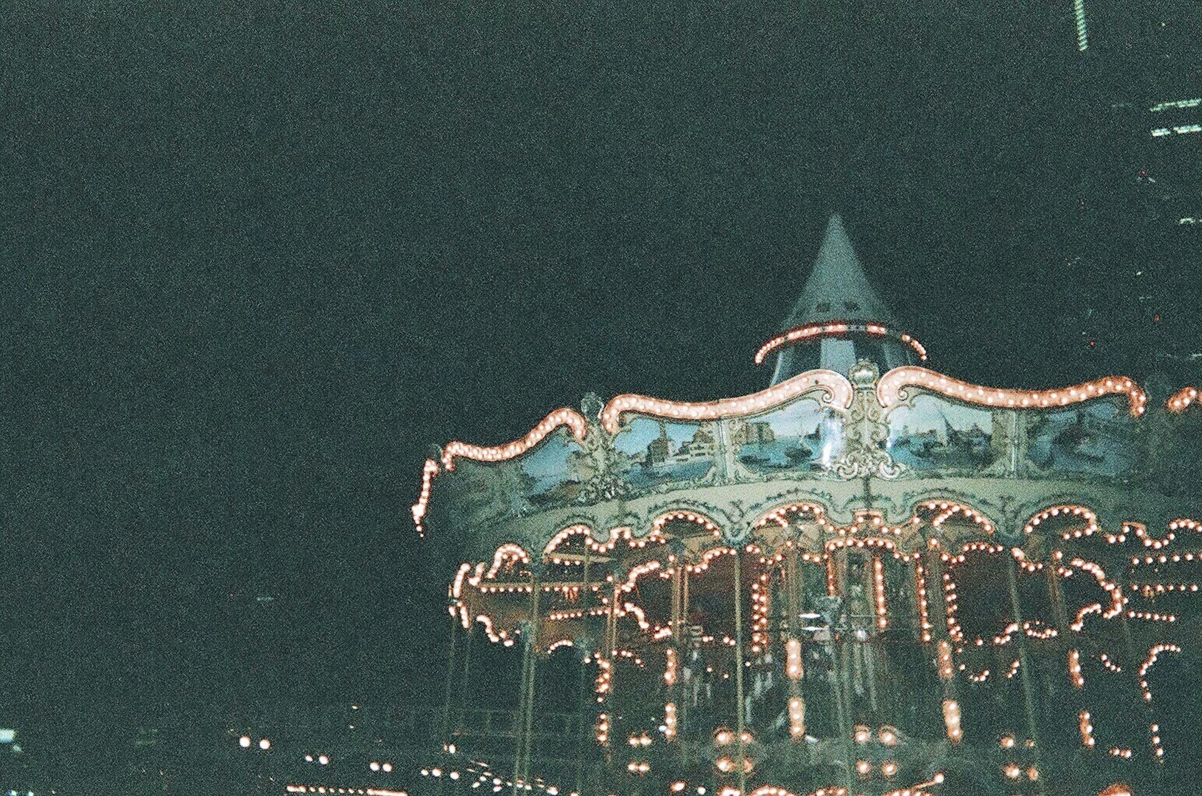 Brightly lit carousel at night in an amusement park