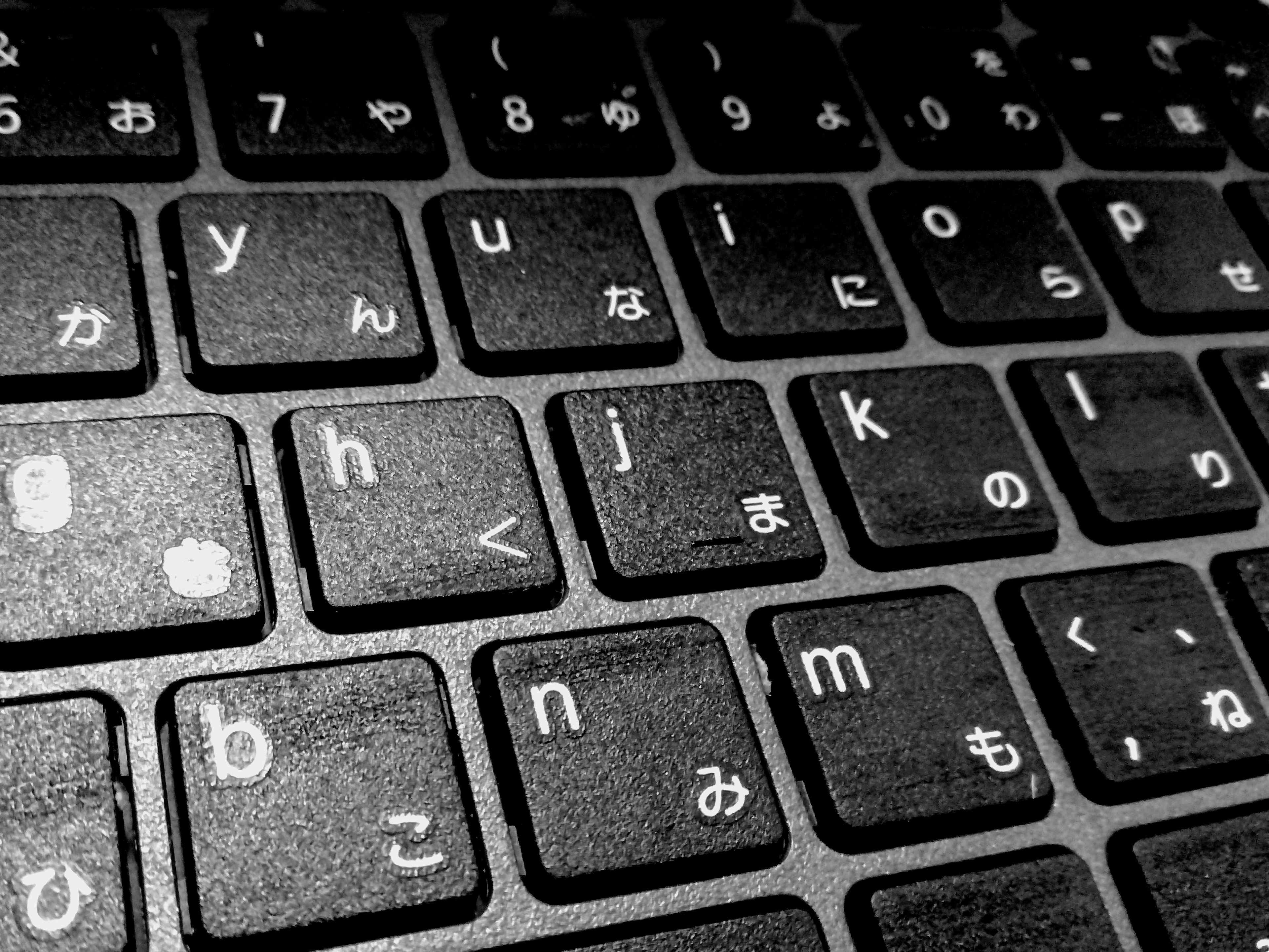 Close-up dari keyboard hitam yang menampilkan karakter hiragana Jepang