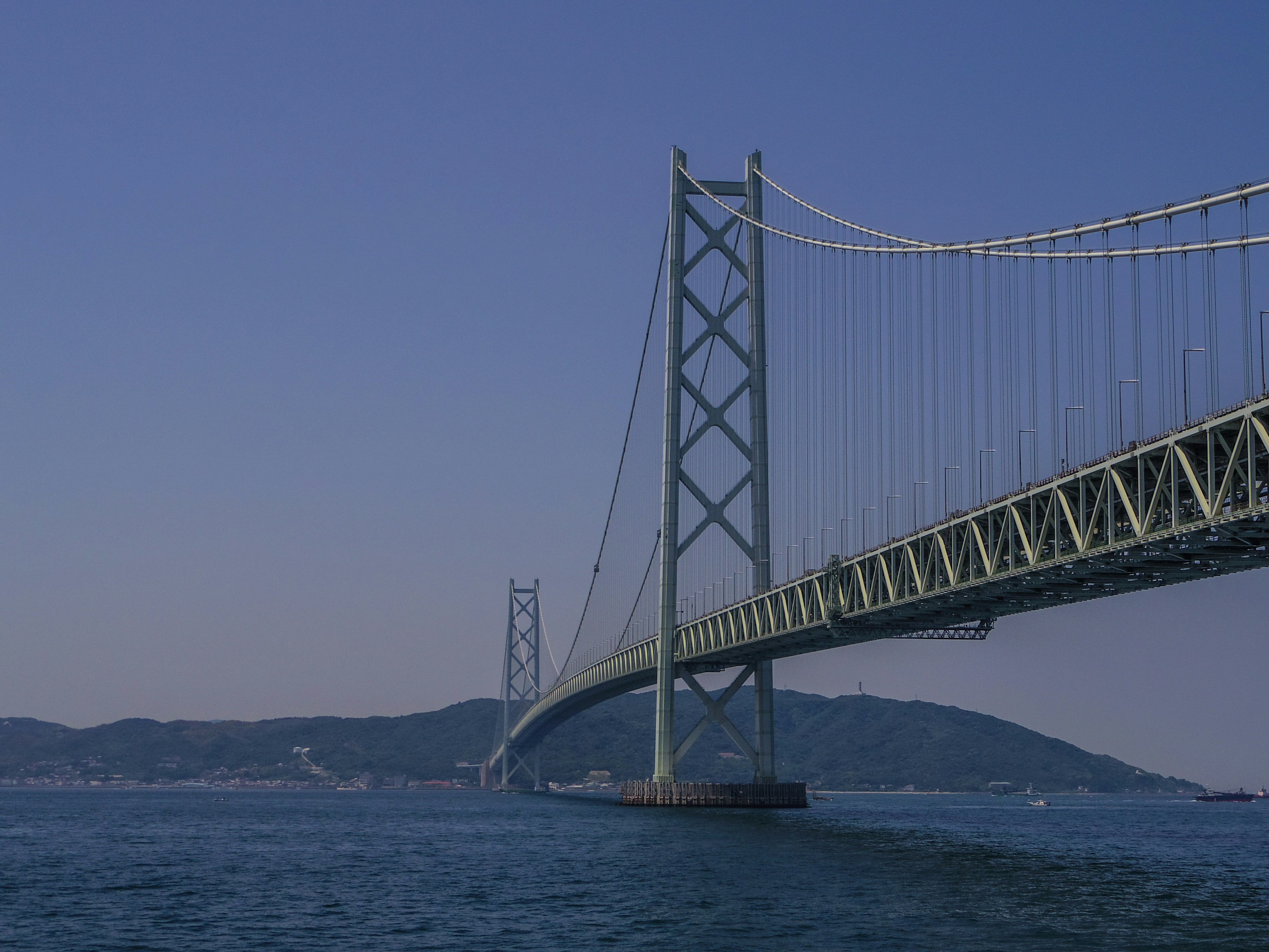 青い空の下に立つ美しい吊り橋と海の景色