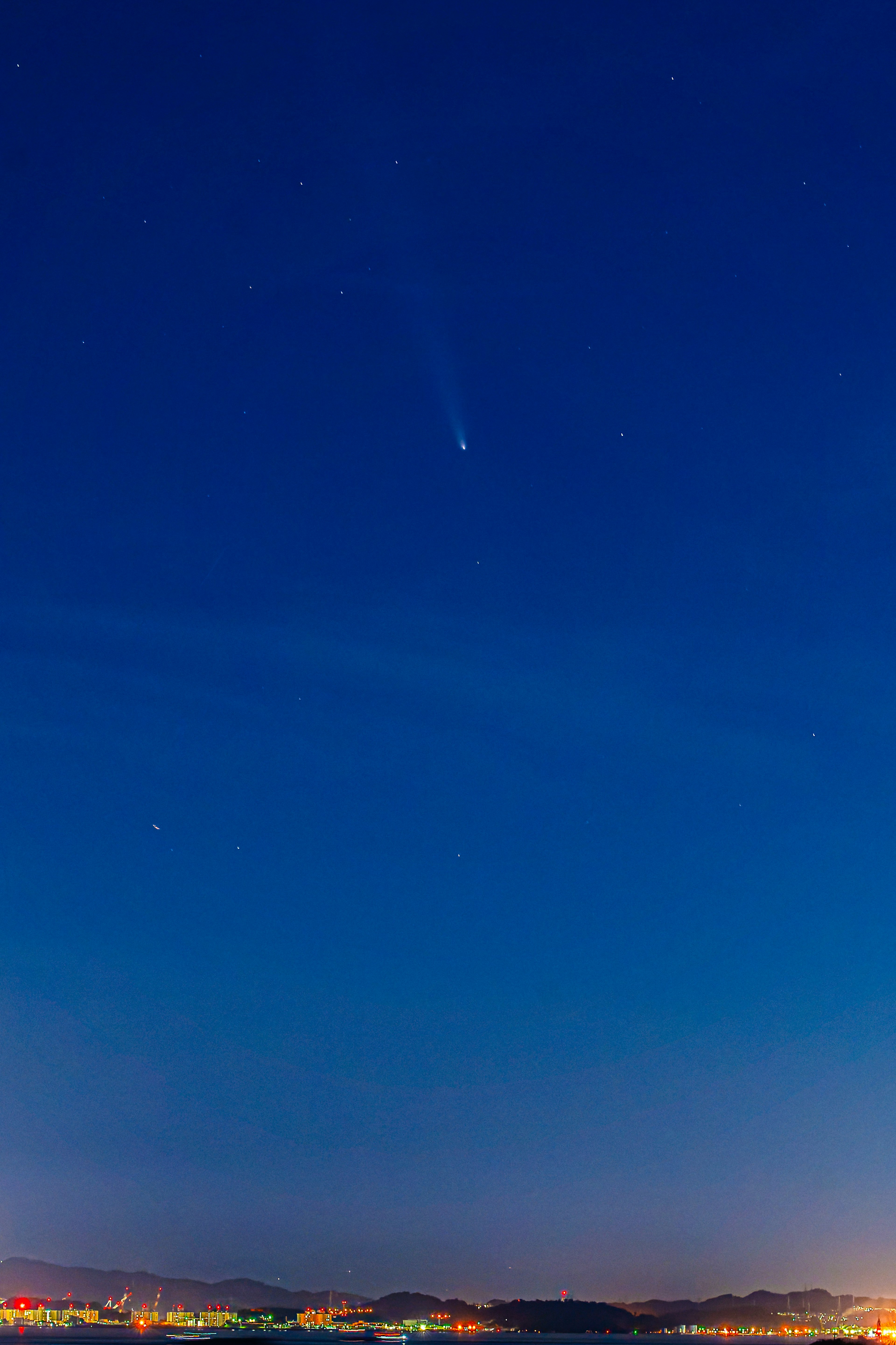 夜空中可见的彗星与星星和城市天际线