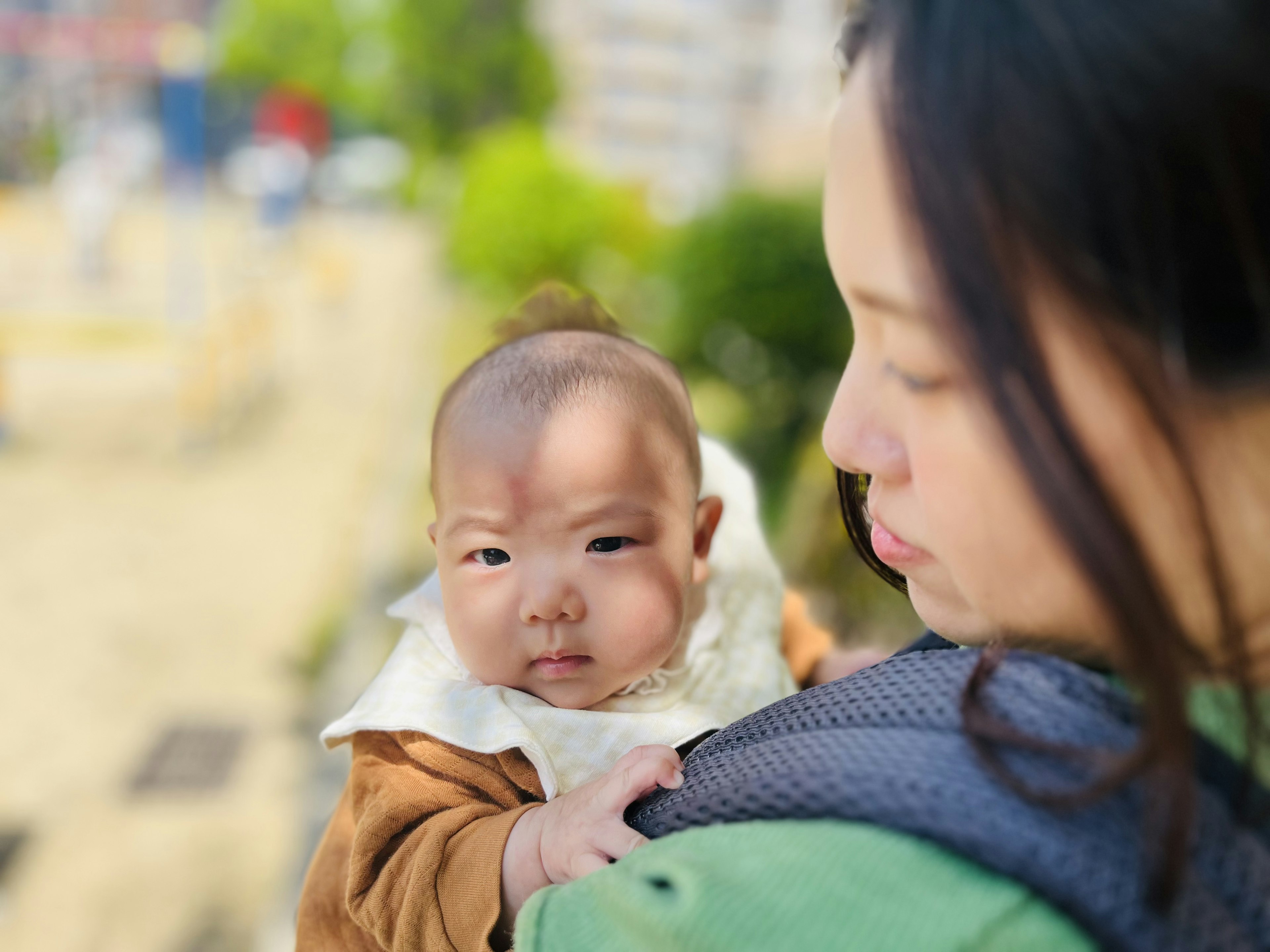 Potret wanita yang menggendong bayi dengan latar belakang kabur