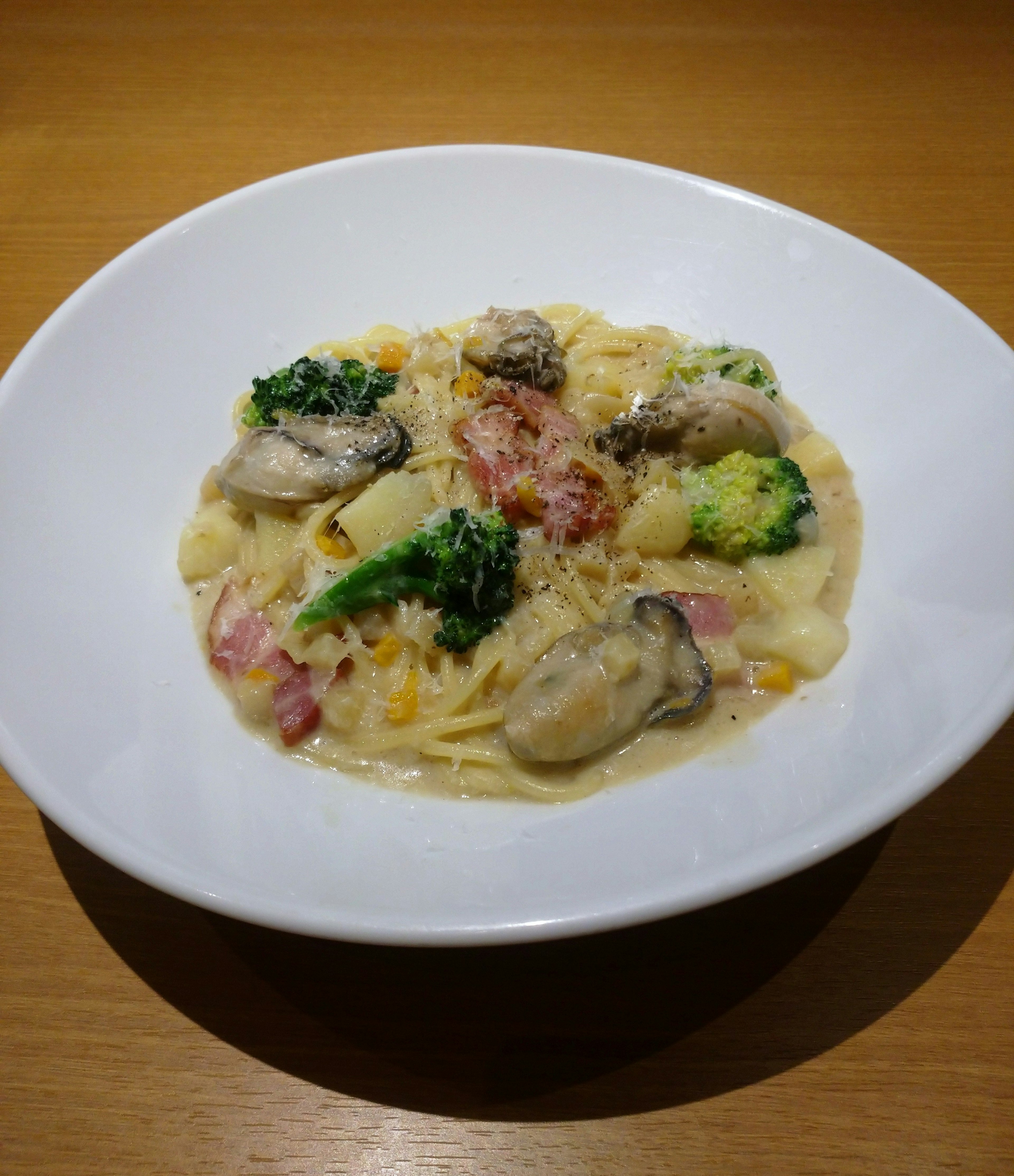 Pasta en salsa cremosa cubierta con ostras y brócoli