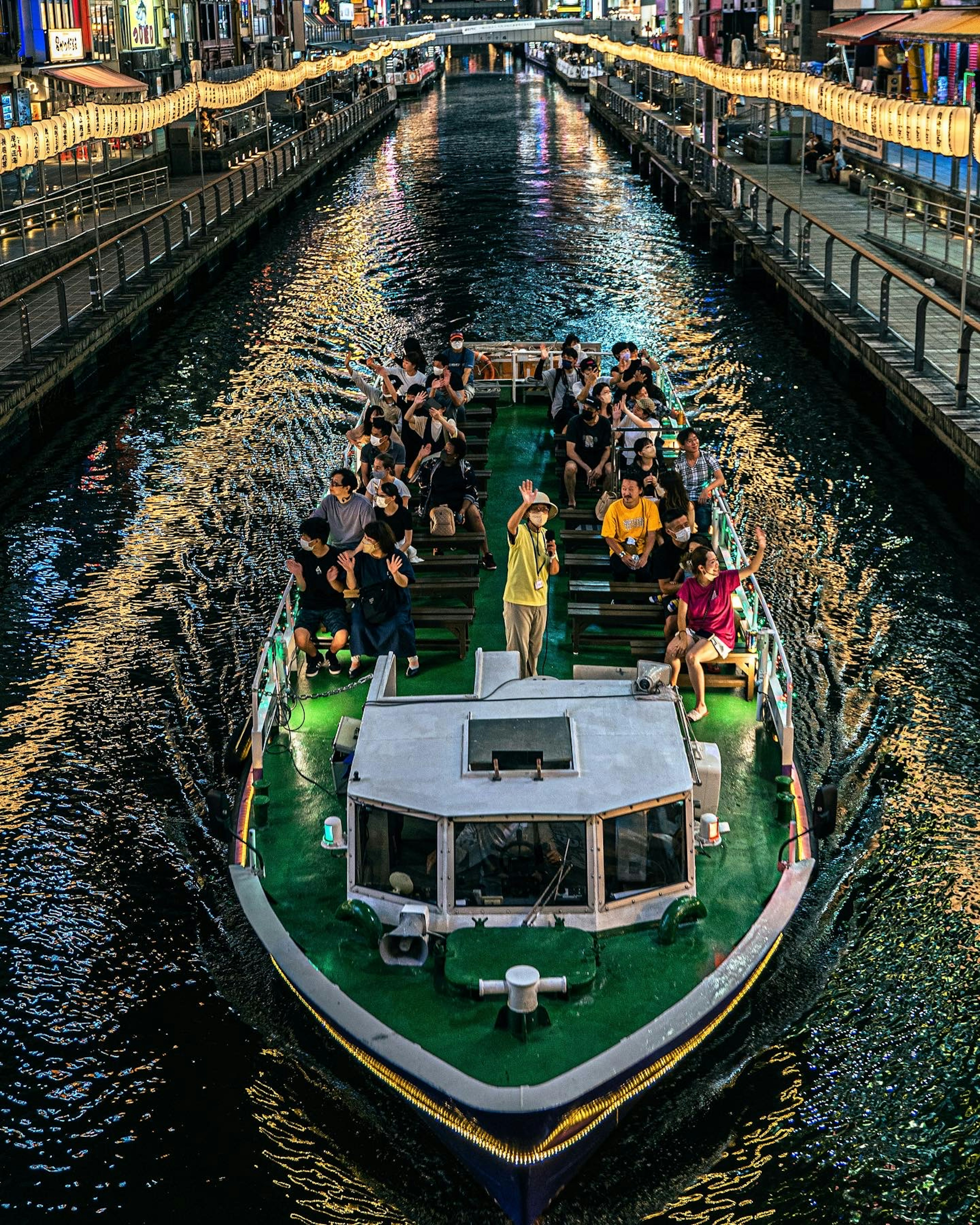 Tourist boat navigating a canal at night with passengers