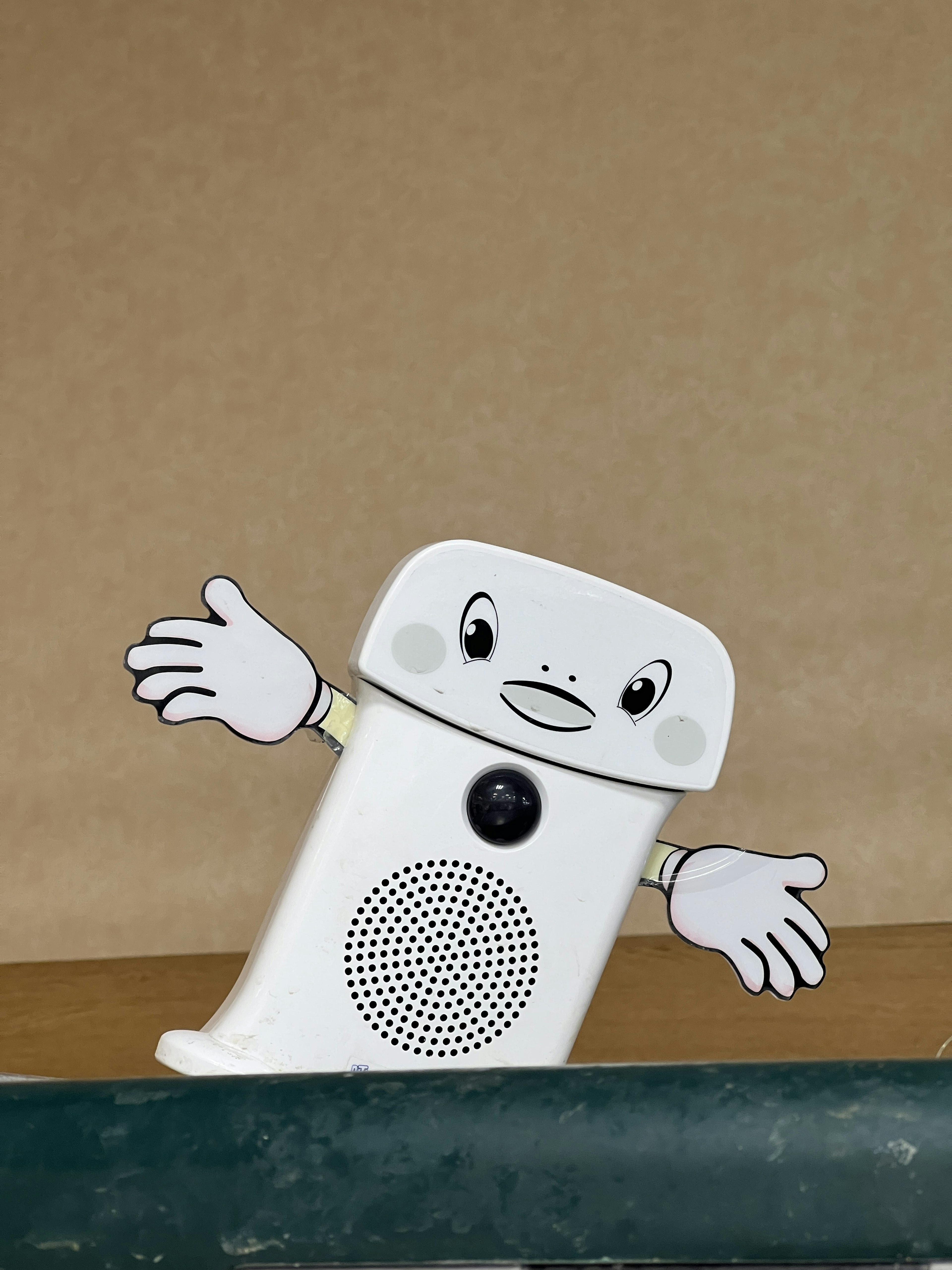 A white speaker with an animated character waving its arms