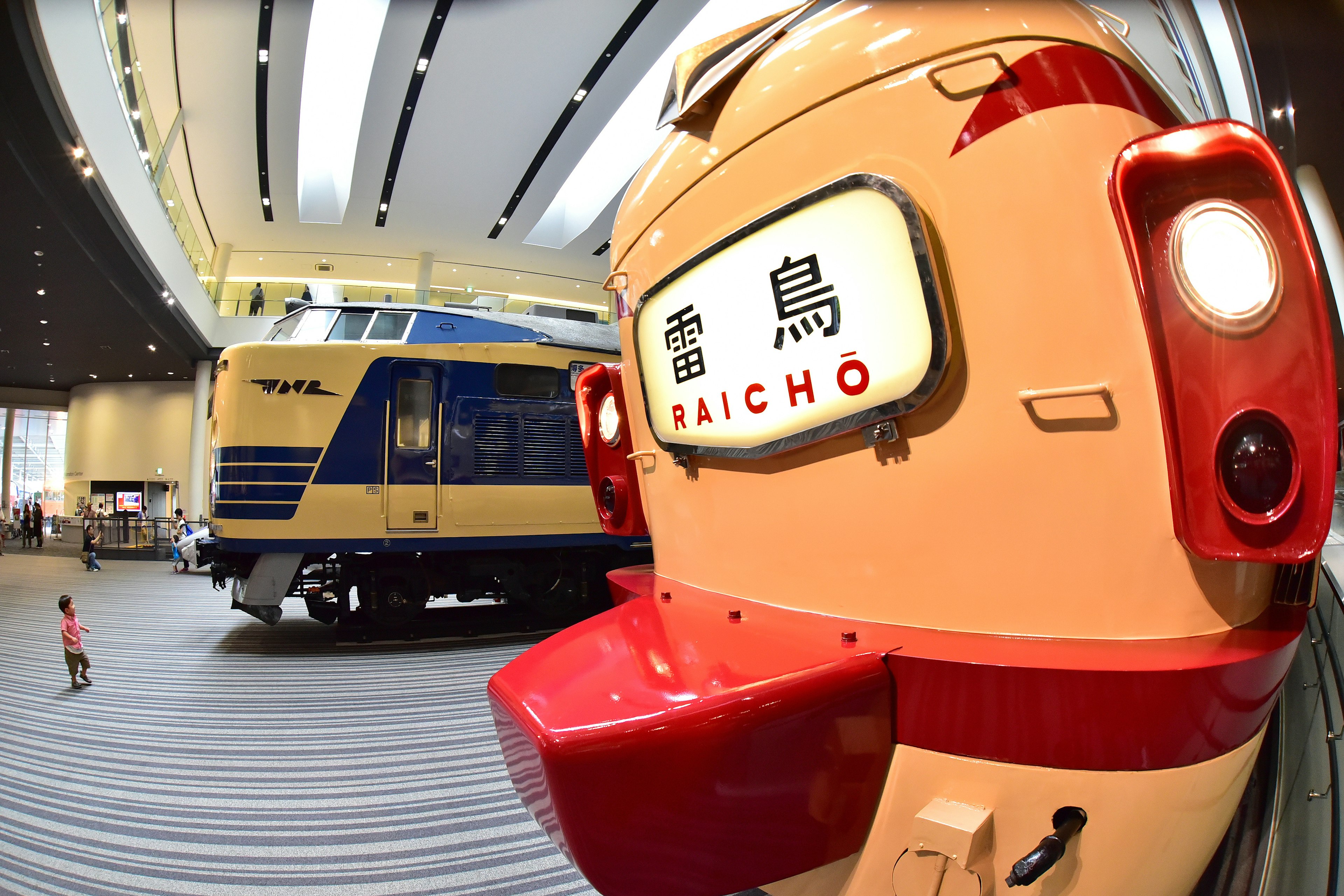 Interior of a museum featuring vintage trains with a focus on a red front of a train