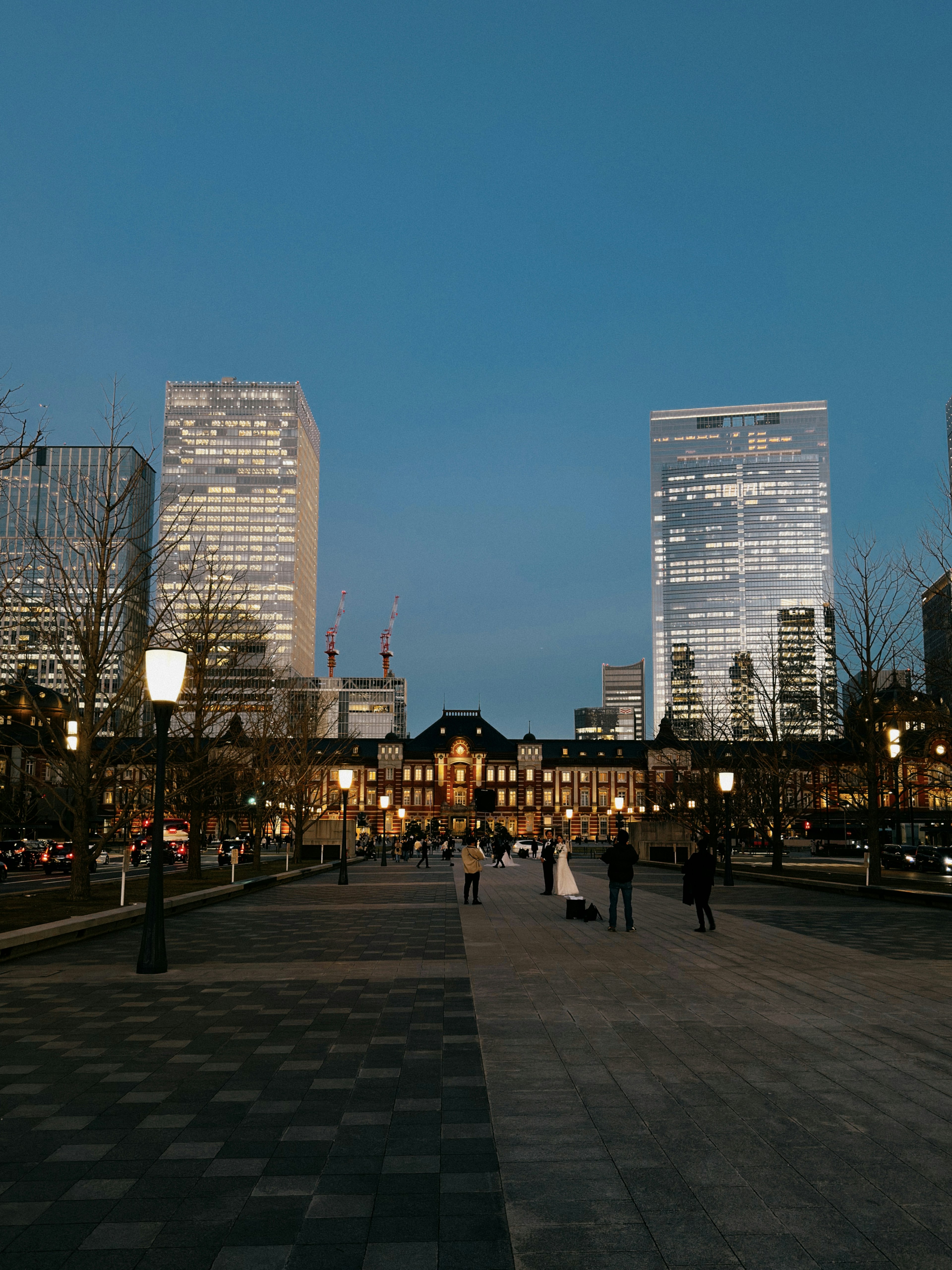 夜景の街並みと高層ビルが並ぶ東京駅周辺の広場