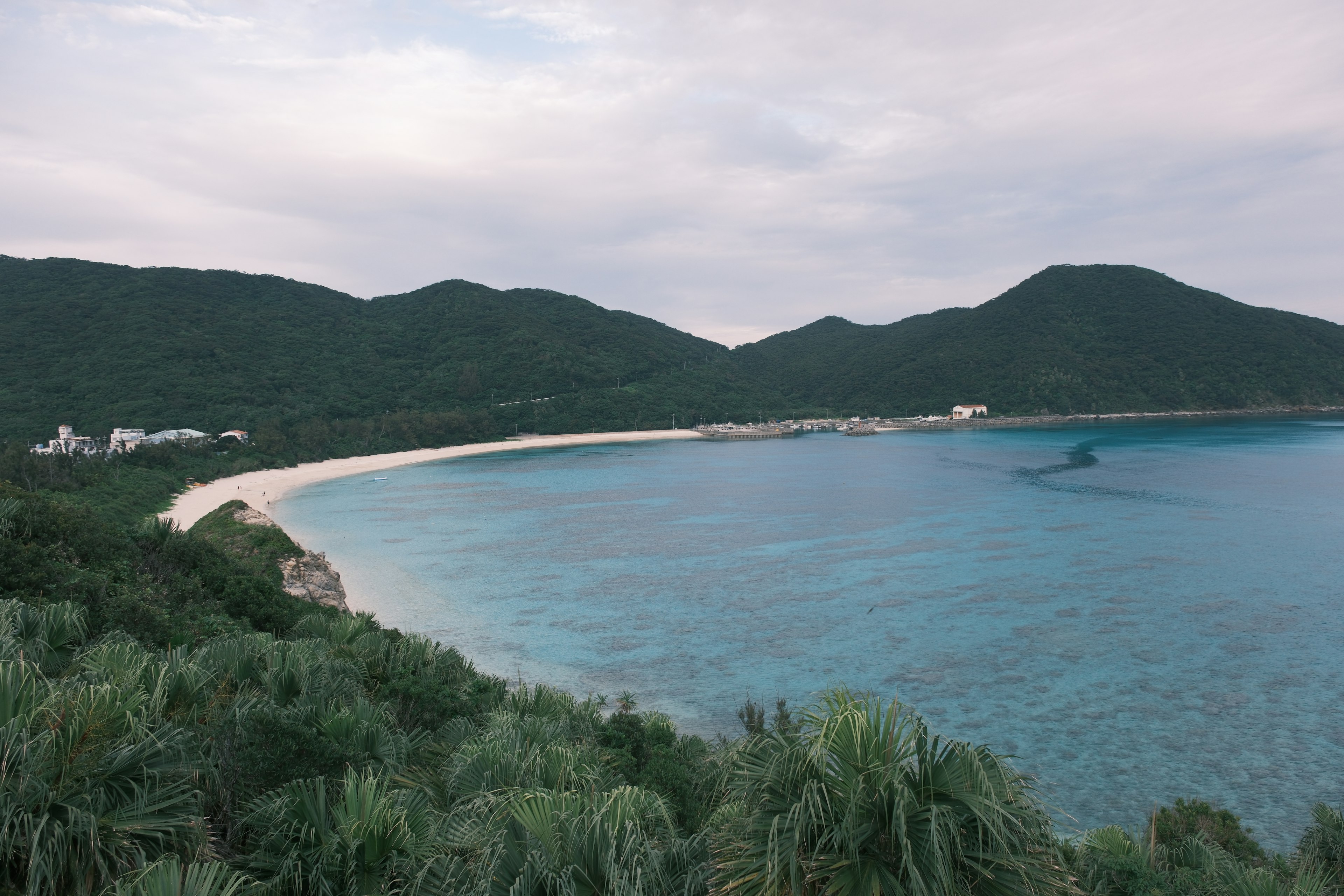 Vista escénica de una playa con montañas y agua clara