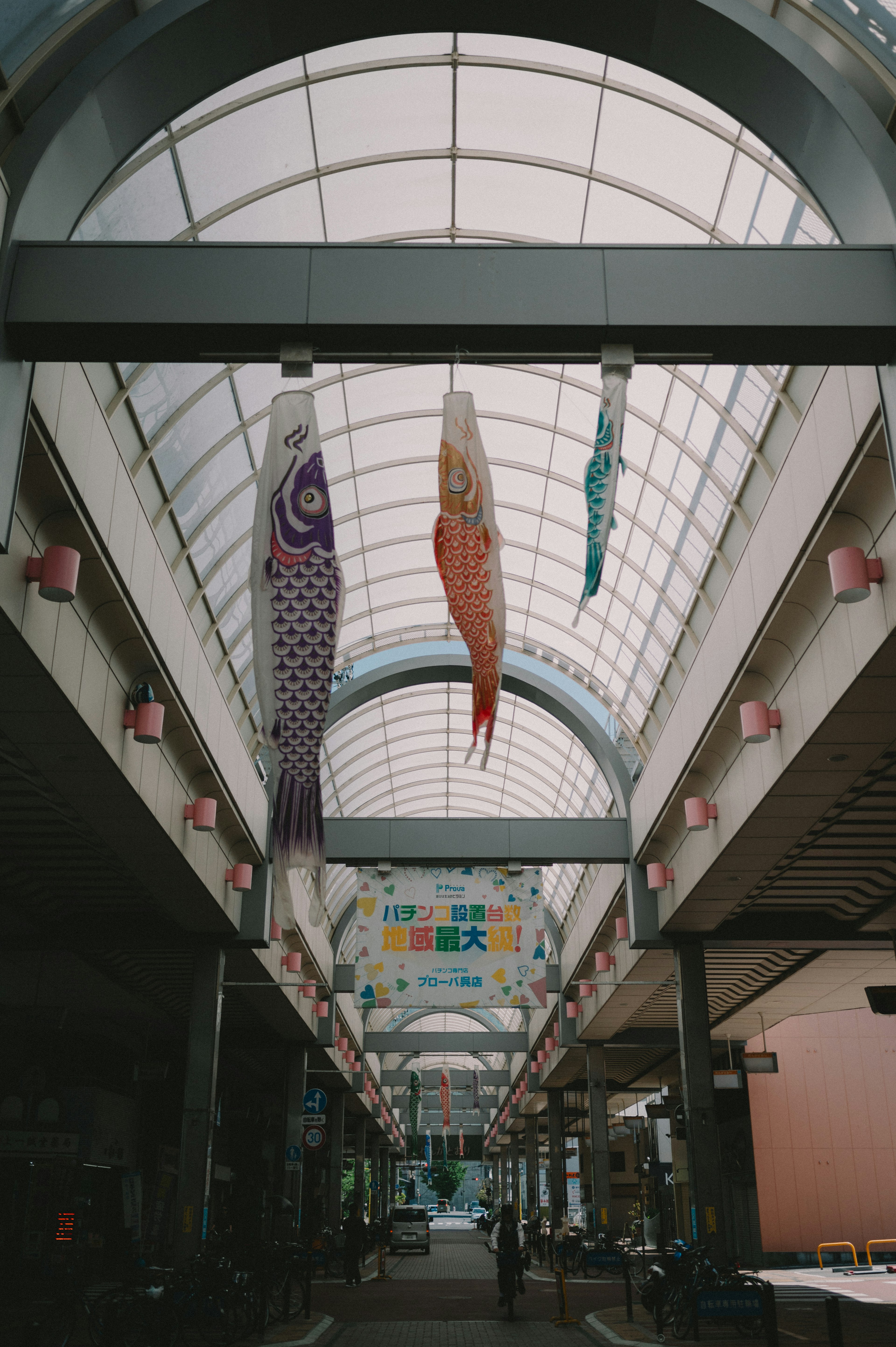 Une rue commerçante avec des décorations de poissons koi colorés suspendues au plafond