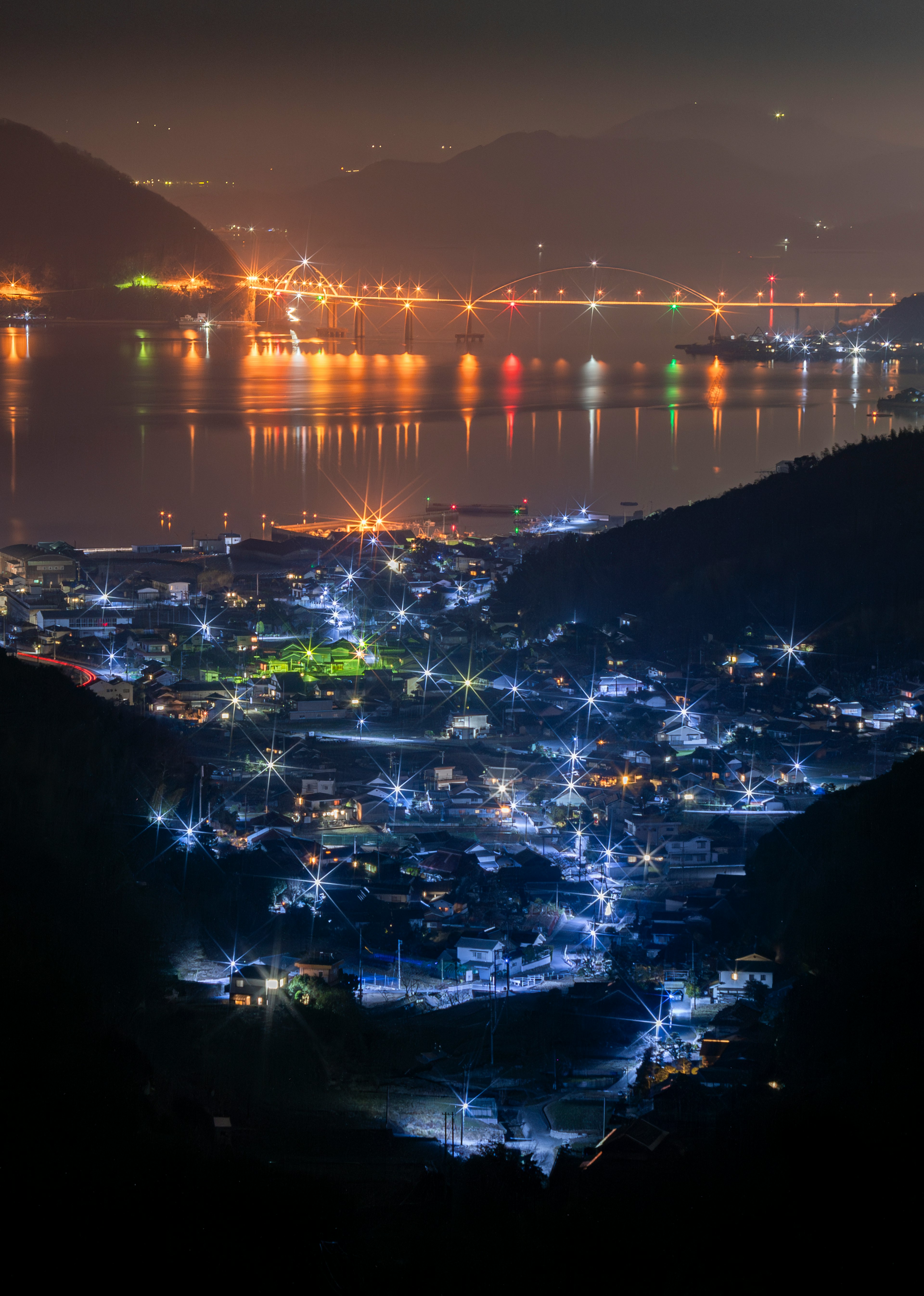 夜景の村と海の風景が広がる美しい画像