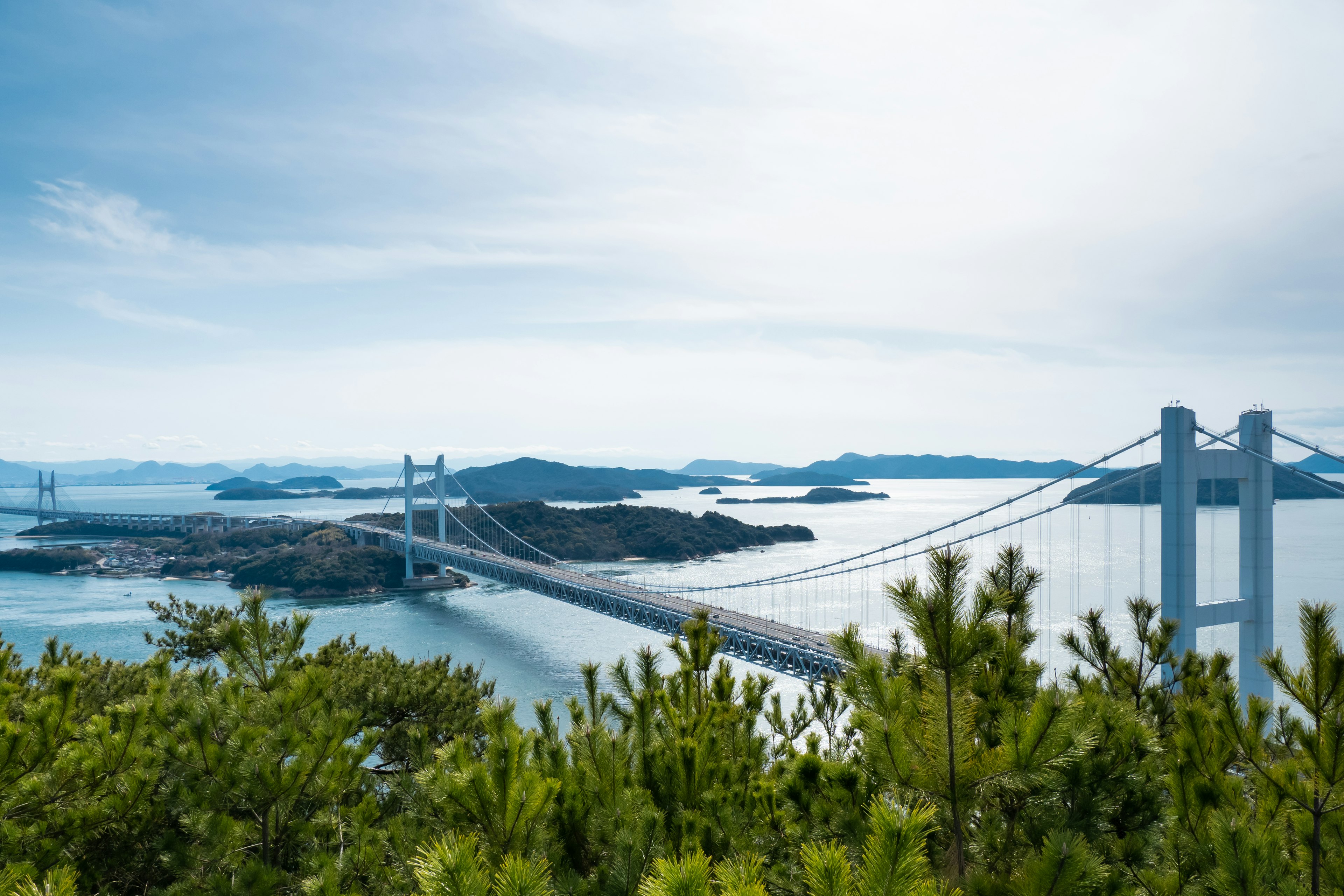 Scenic view of a bridge over the sea surrounded by islands and greenery