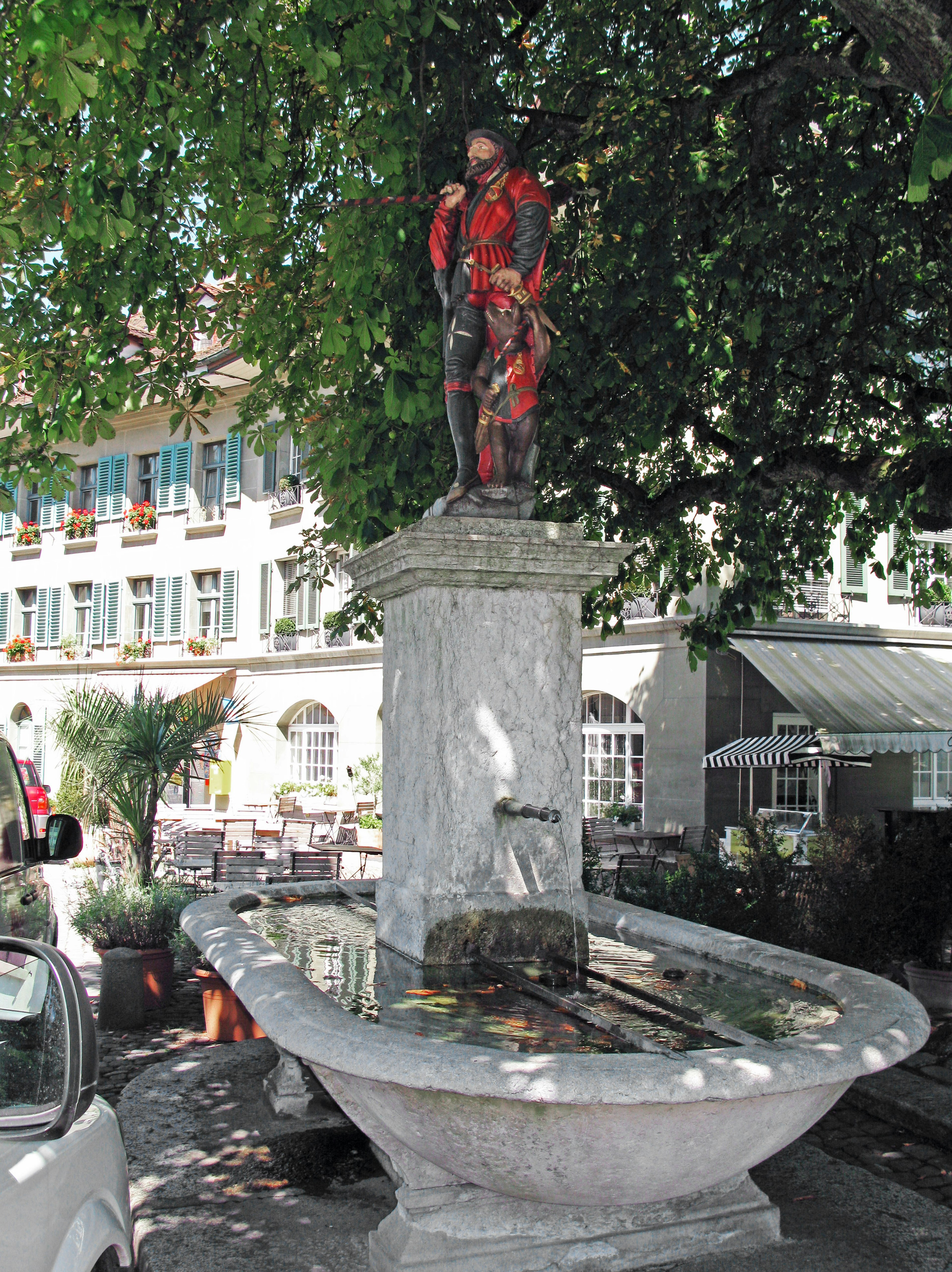 Stone fountain with a statue in red clothing