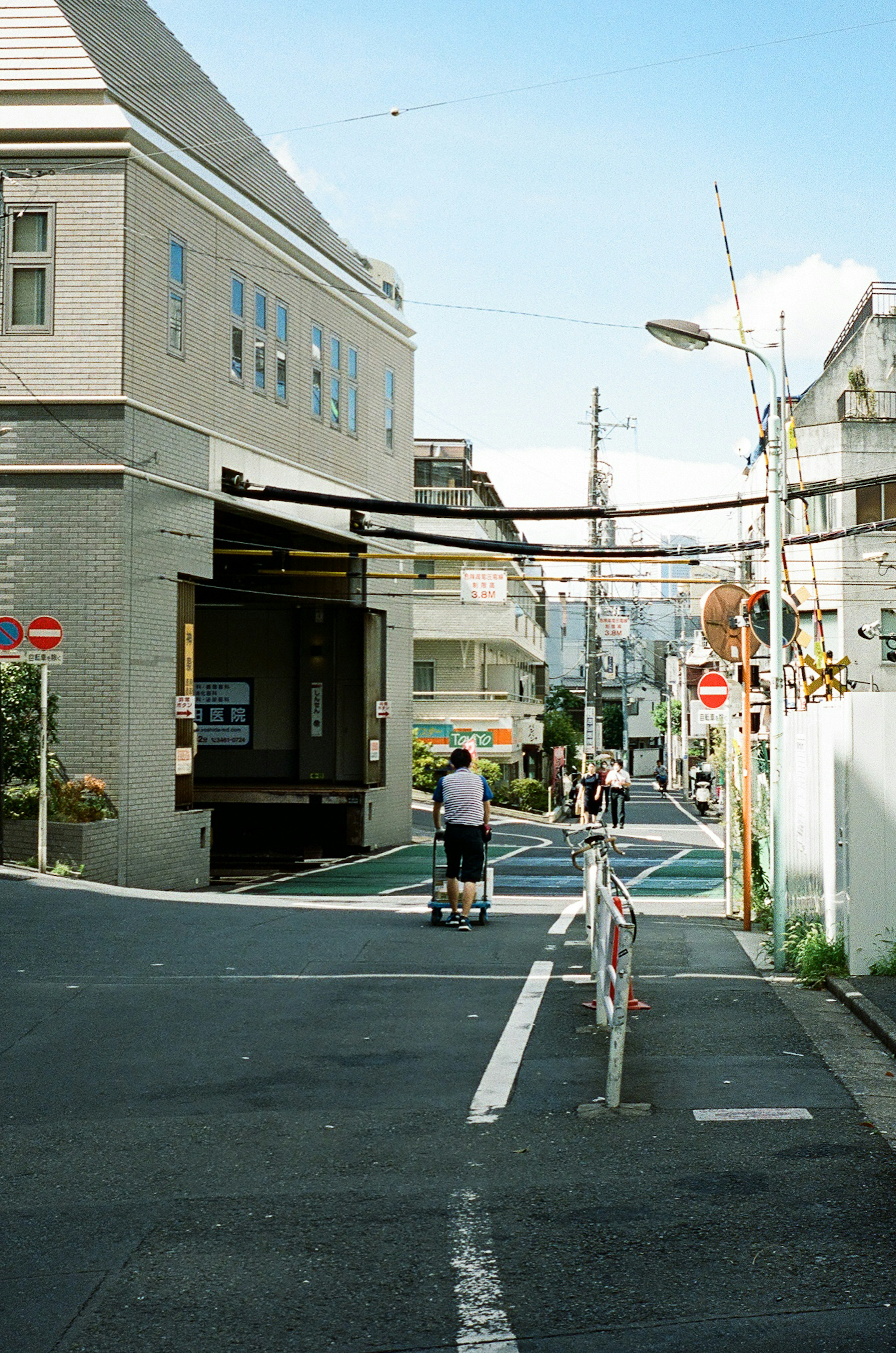 狭い街道に沿った建物と人々が見える風景