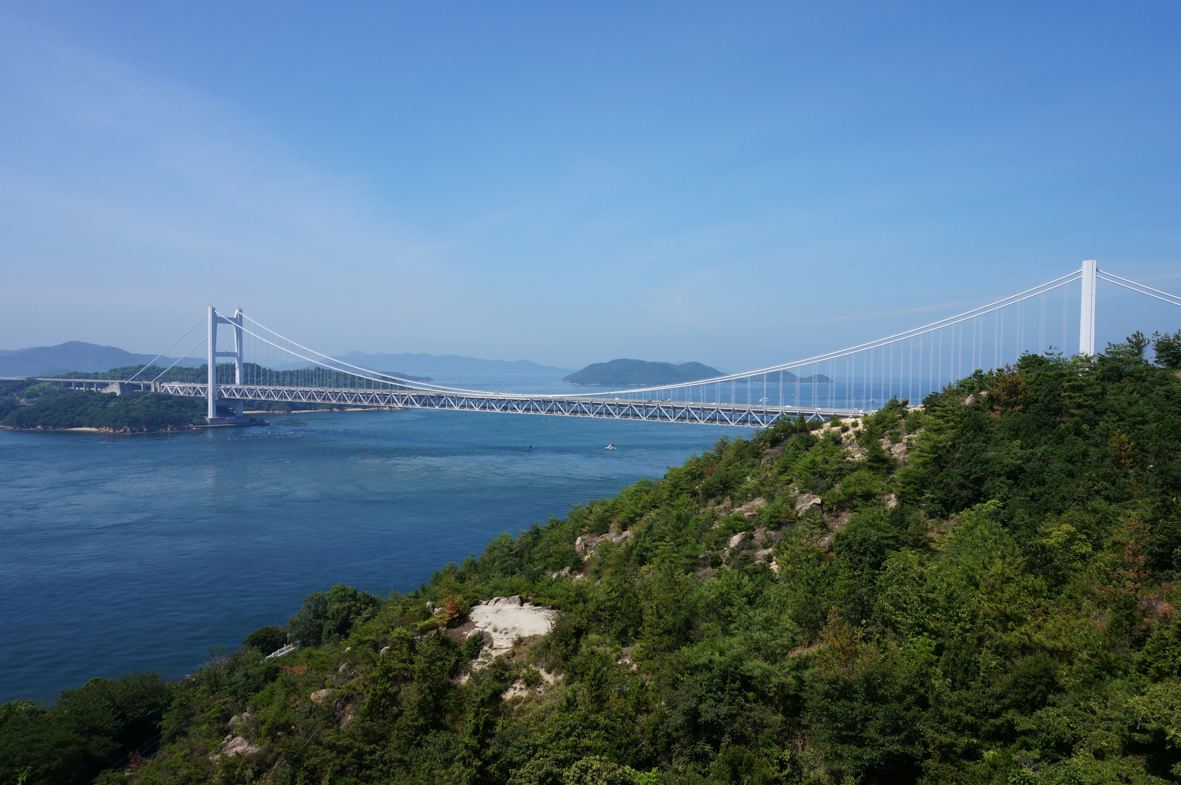 大桥横跨美丽的海洋，绿树成荫的山丘