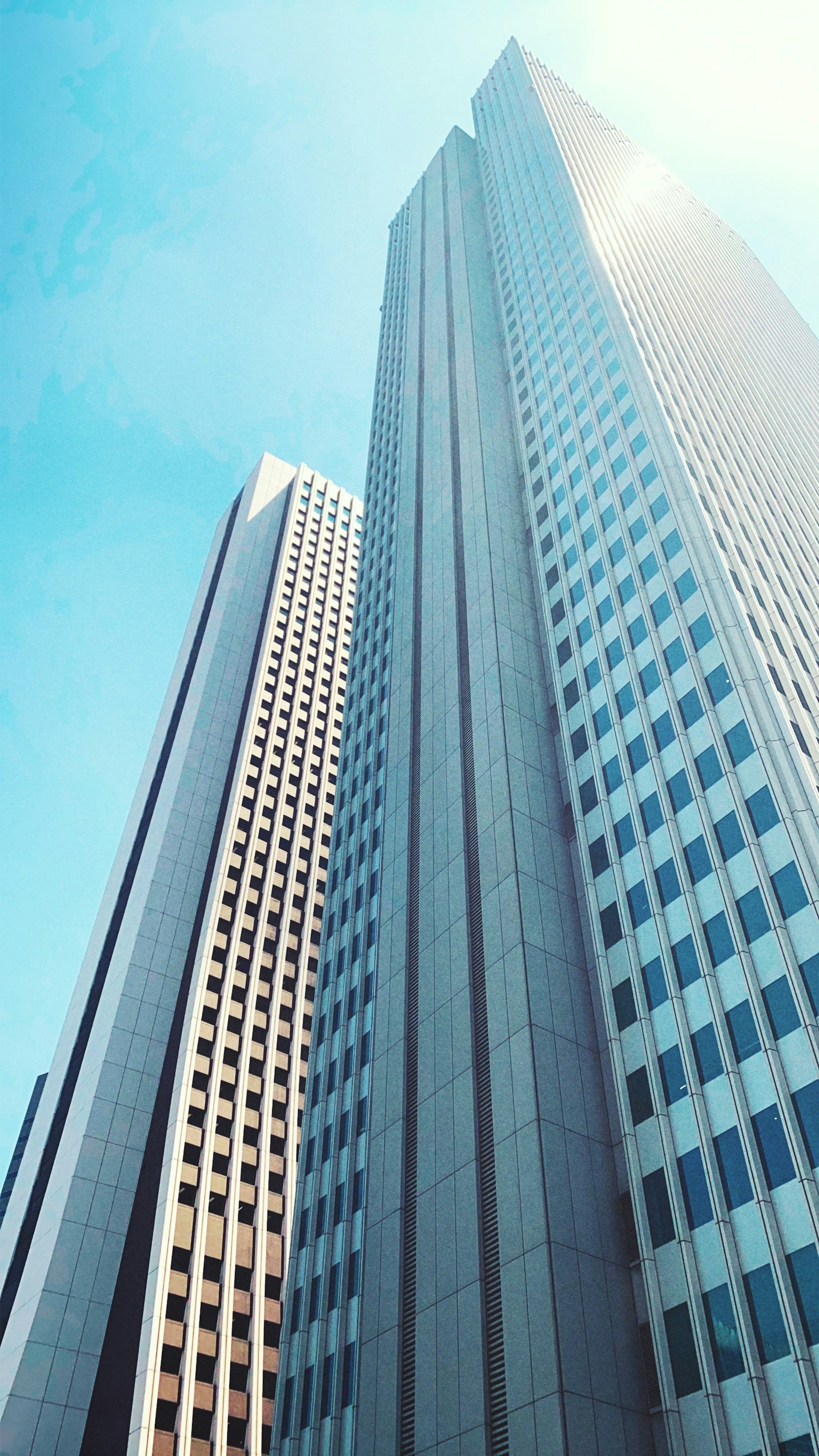 Close-up of skyscrapers under a blue sky showcasing architectural design