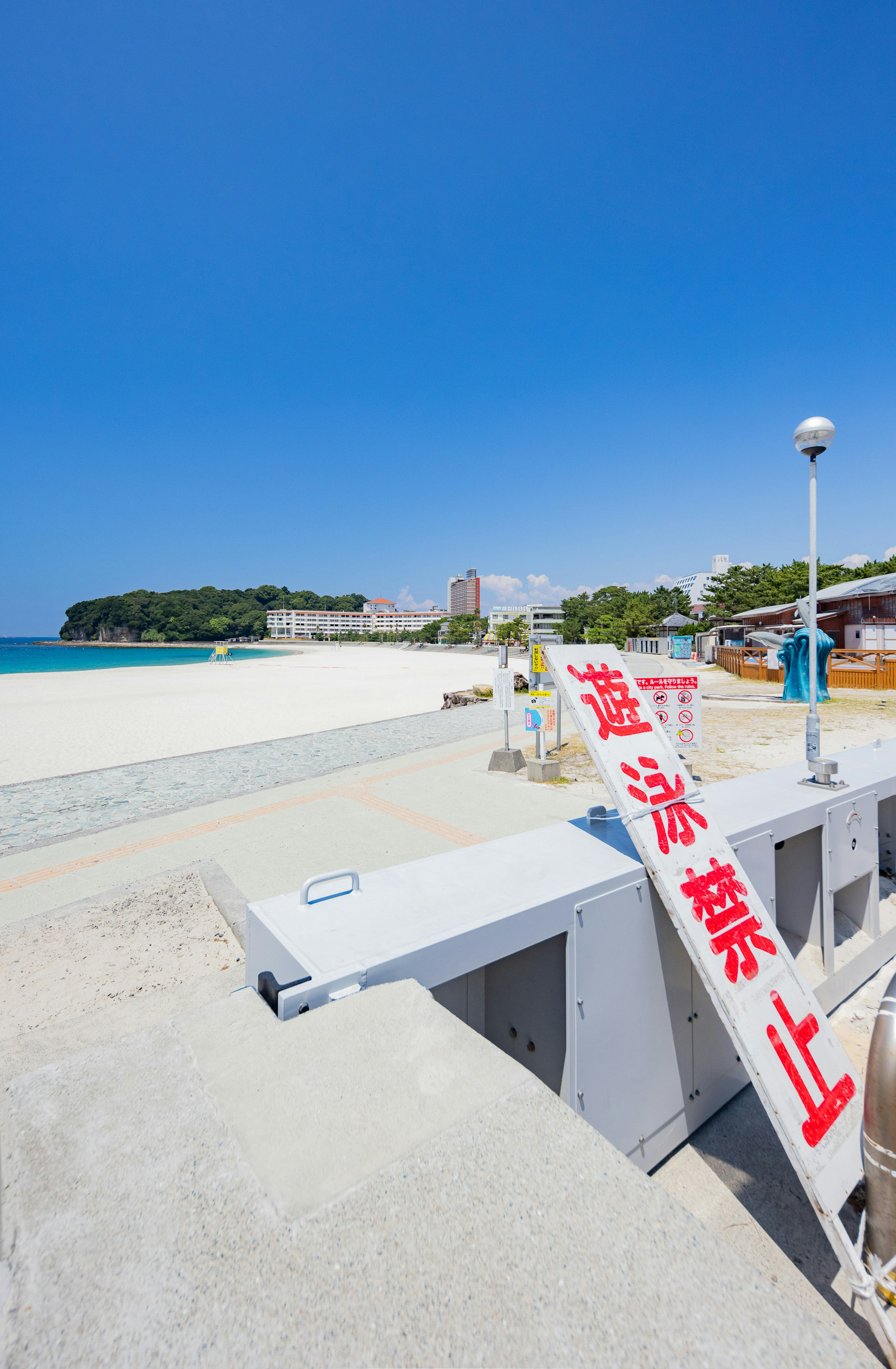 Spiaggia con un cartello di divieto di balneazione e cielo azzurro